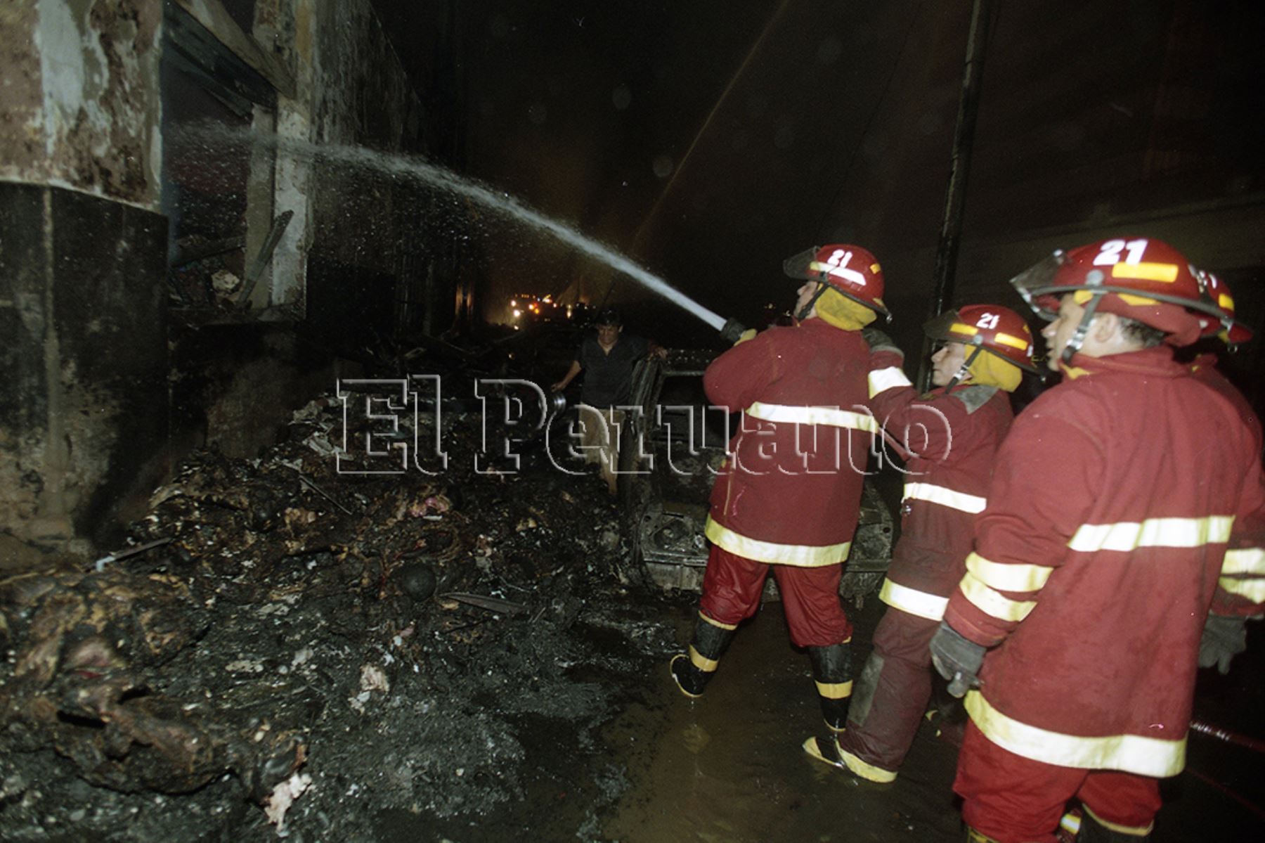 Lima - 29 diciembre 2001 / Bomberos tratan de apagar el fuego en la zona comercial Mesa Redonda en el centro de Lima. Foto: Archivo Histórico de EL PERUANO / Jack Ramón