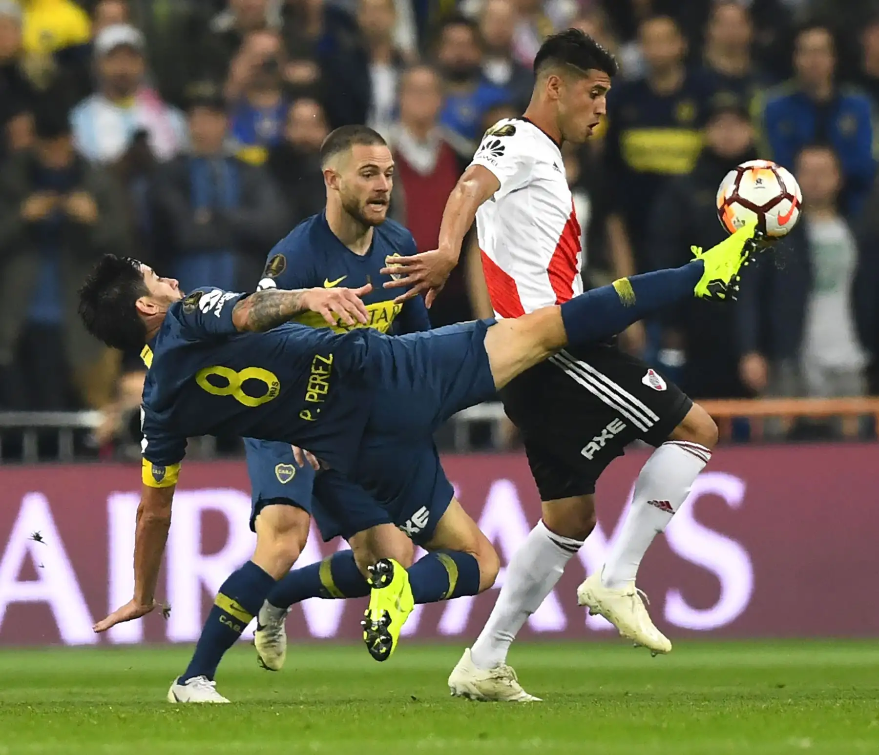 El jugador de Boca Juniors, Pablo Pérez (8) y el uruguayo Nahitan Nandez (C) de Boca Juniors, marcaron a Exequiel Palacios (R) de River Plate durante el partido de ida de la final de la Copa Libertadores argentina, en el estadio Santiago Bernabeu de Madrid, en diciembre. 9, 2018. AFP