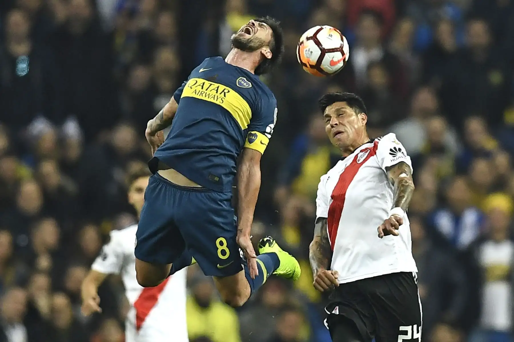 Pablo Pérez (L), de Boca Juniors, y Enzo Pérez, de River Plate, saltan a la pelota durante el partido de la segunda etapa de su final de la Copa Libertadores argentina, en el estadio Santiago Bernabéu de Madrid, el 9 de diciembre de 2018. AFP