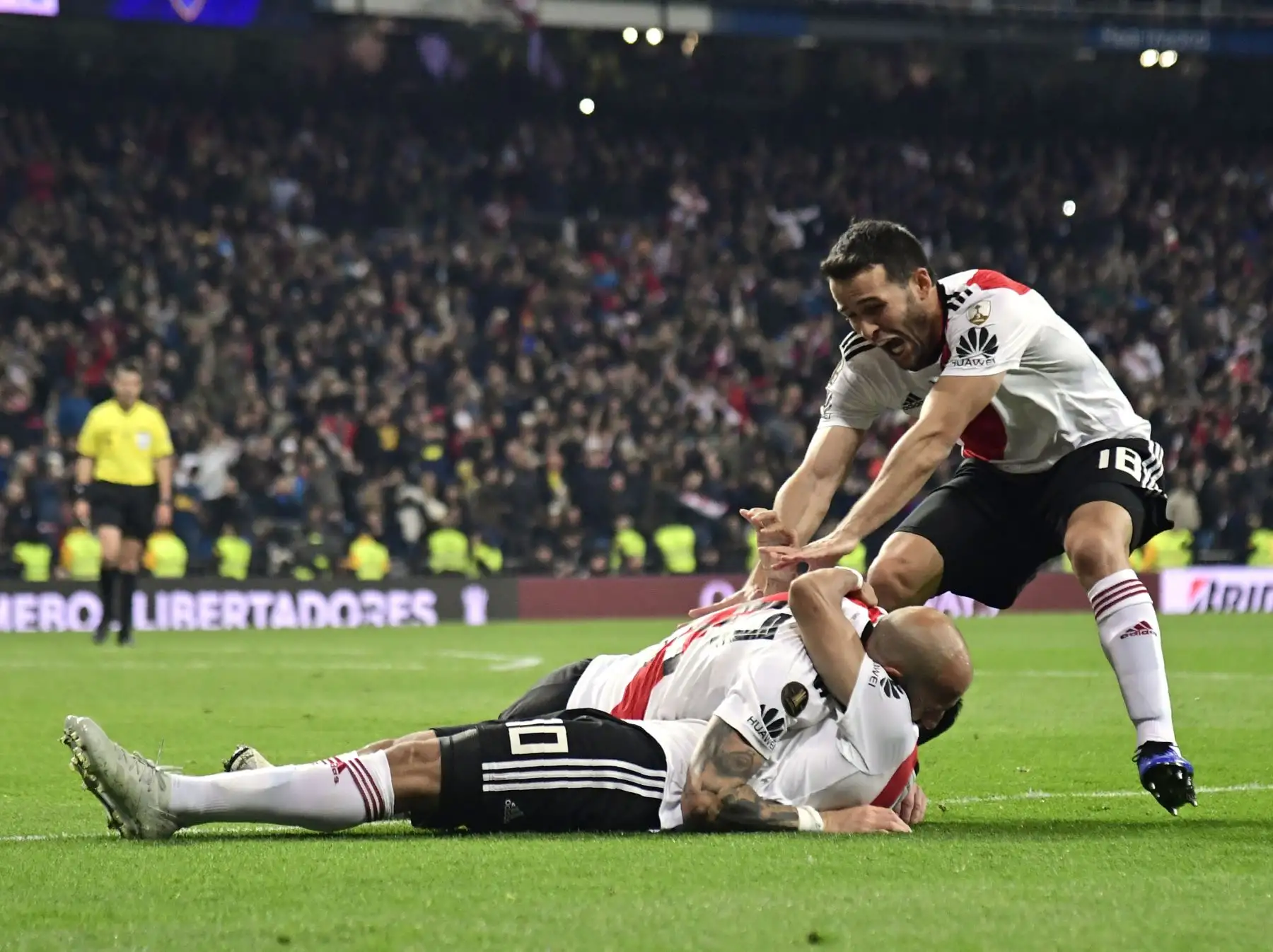 Gonzalo Martínez (en el suelo) de River Plate celebra con sus compañeros Javier Pinola (C) y el uruguayo Camilo Mayada luego de anotar contra Boca Juniors en el partido de ida de la final de la Copa Libertadores argentina, en el estadio Santiago Bernabeu de Madrid, en diciembre. 9, 2018. AFP