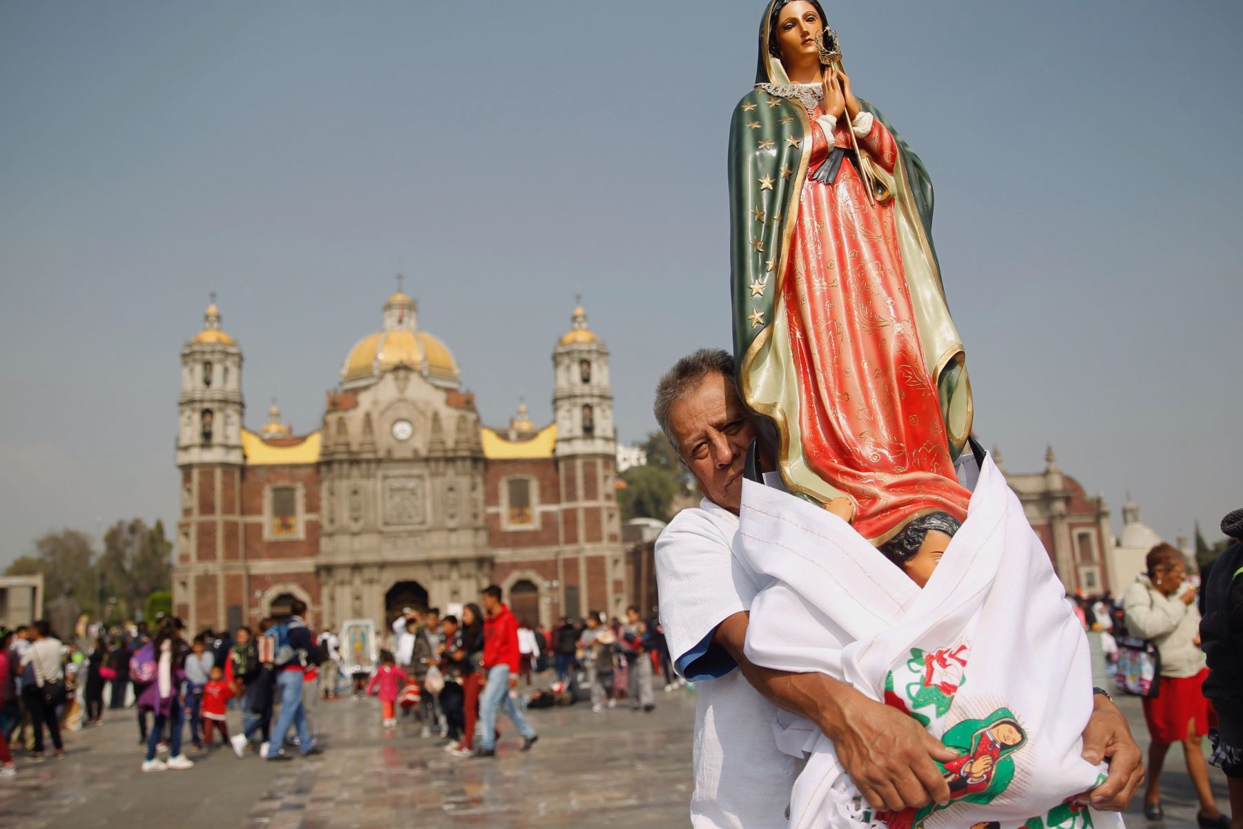 Un hombre carga una imagen de la virgen de Guadalupe, en los exteriores de la BasÃ­lica Foto: EFE