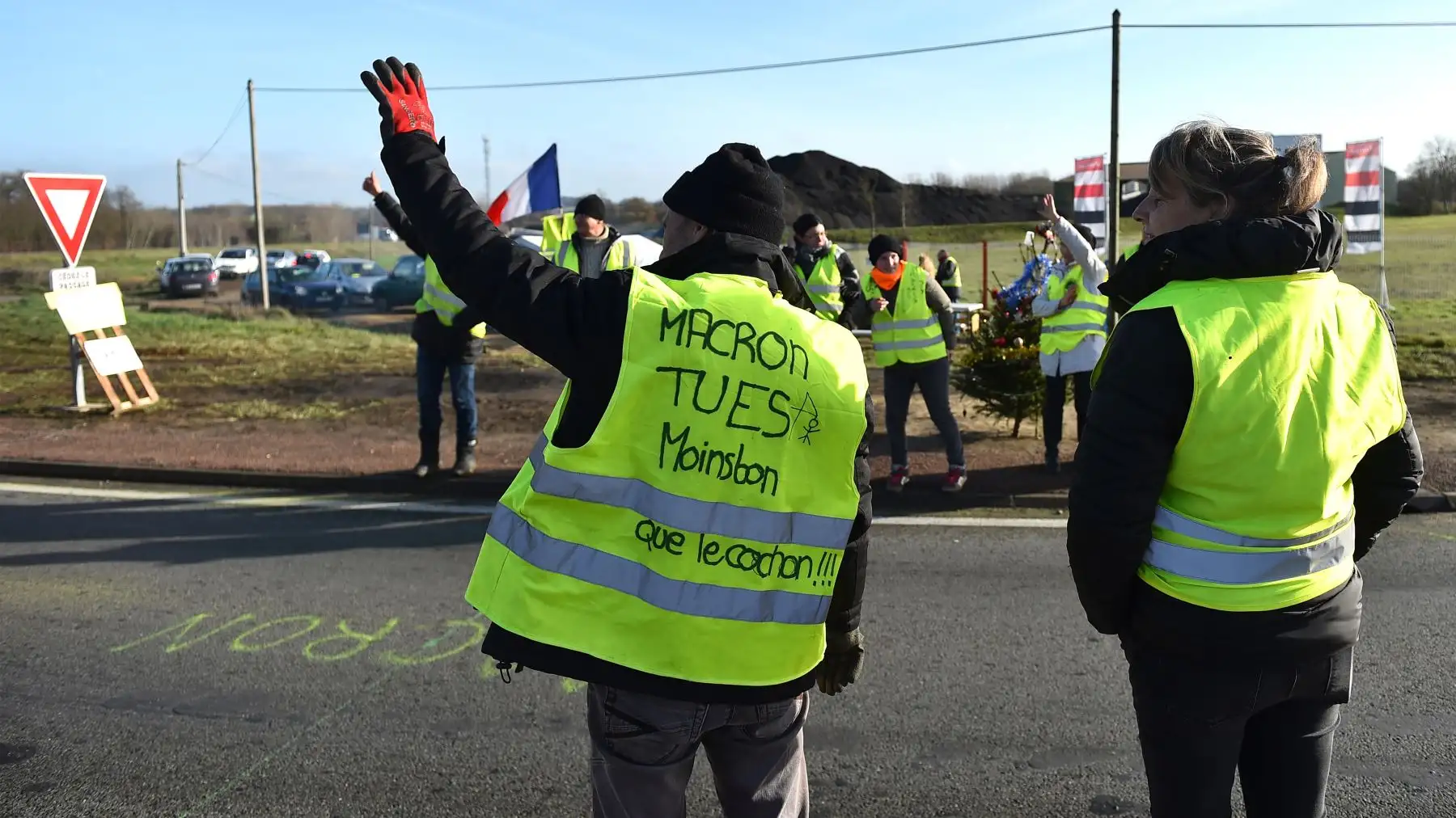 Los manifestantes del chaleco amarillo hacen gestos mientras bloquean una de las vías de acceso a la carretera de circunvalación de South Le Mans. AFP