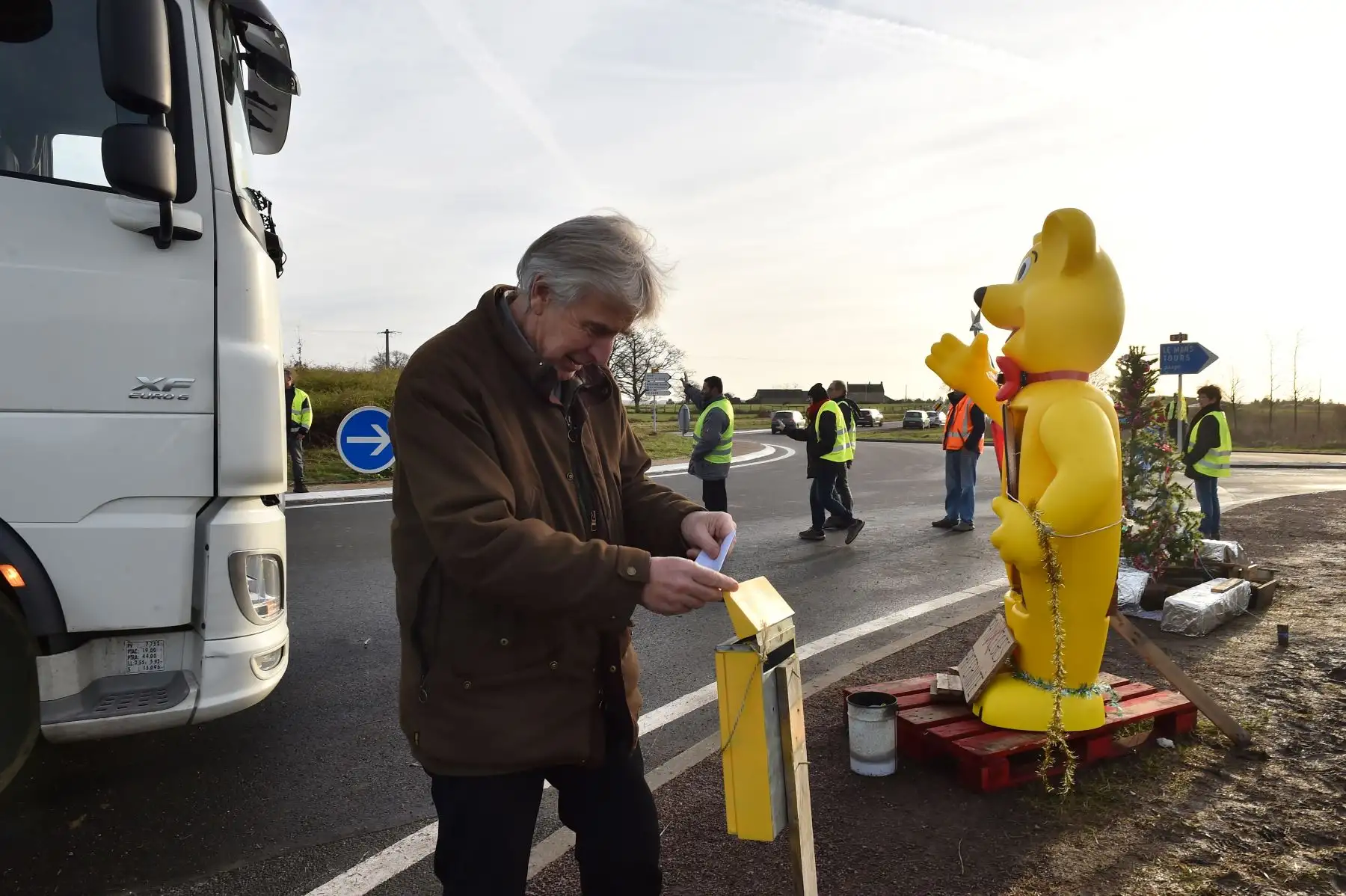 Un automovilista deposita en una caja colocada por chalecos amarillos que protestan el cuestionario sobre el referéndum de la Iniciativa Ciudadana (PCI) en el lado de la autopista A28, en Montabón. AFP