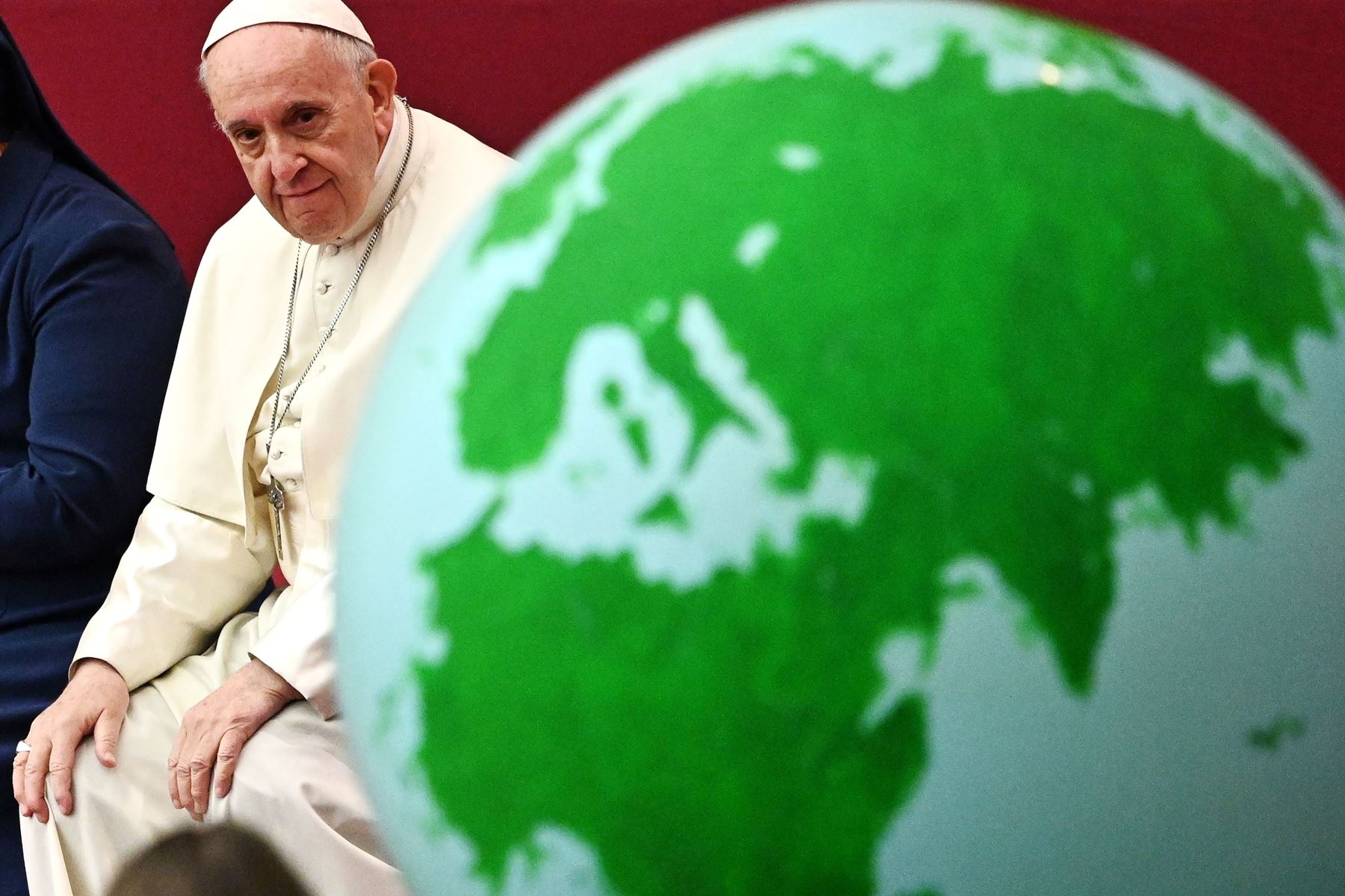 El Papa Francisco mira un globo terráqueo de la Tierra durante una audiencia para niños y familias del dispensario de Santa Marta Foto: AFP