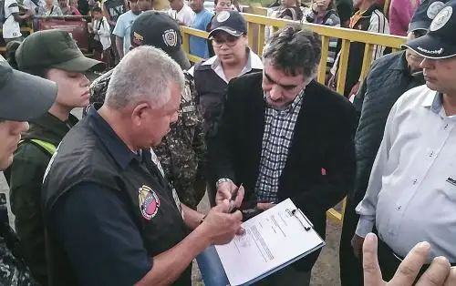 Oficiales de migración colombianos conversan con Carlos Manuel Pino, asesor de la embajada de Venezuela en Colombia, en el puente internacional Simón Bolívar en la frontera entre Venezuela y Colombia Foto: AFP