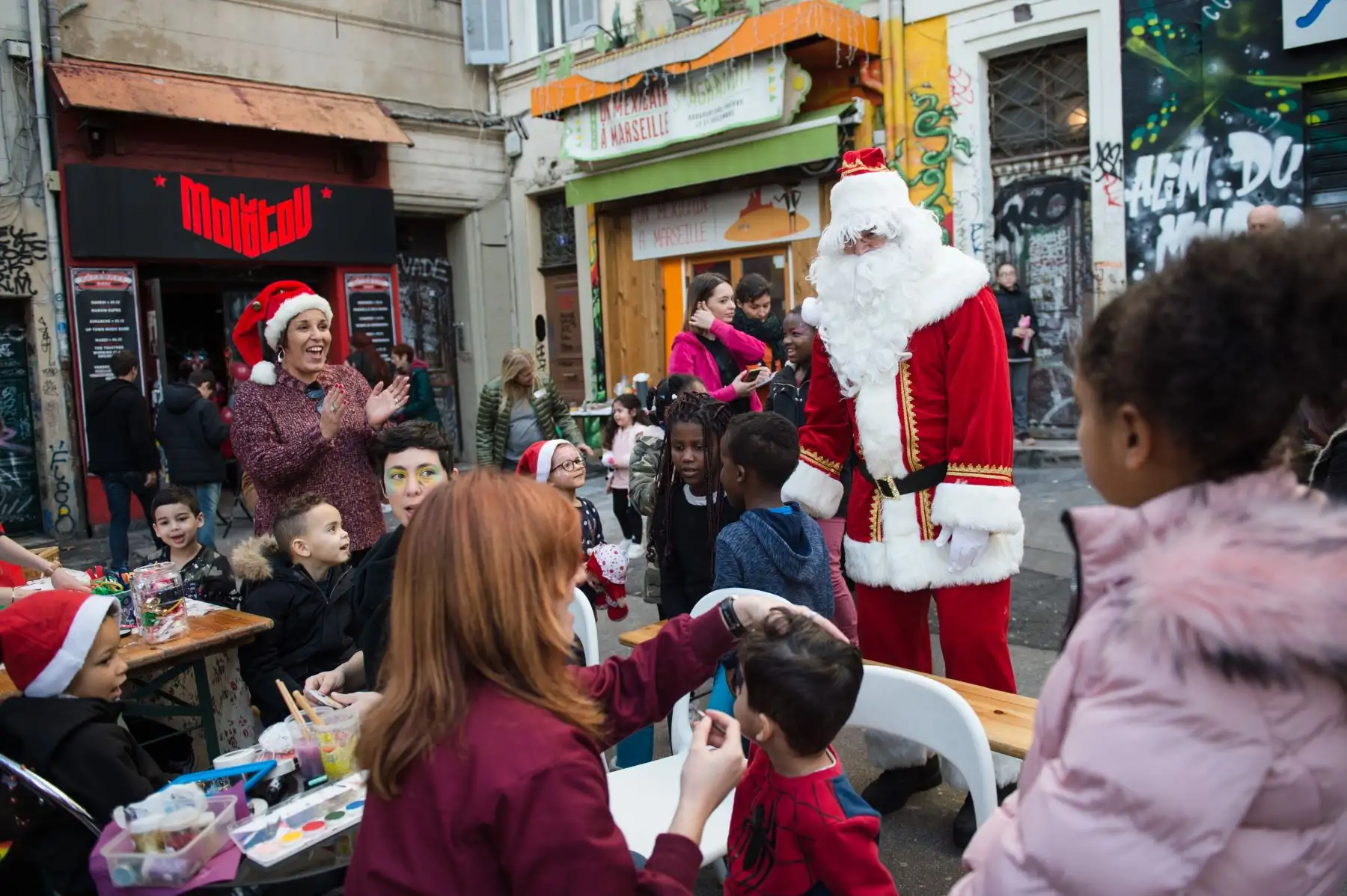 Un animador vestido como Papá Noel se para con los niños el , en la sede Molotov en Marsella, Francia, durante un evento navideño organizado por asociaciones para niños de familias reubicadas como medida de precaución después de la caída de dos edificios en la ciudad. AFP