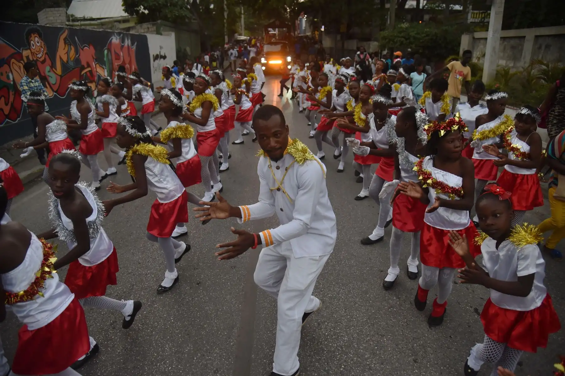 La gente baila en un desfile de Navidad en las calles de la comuna de Petion Ville, en la capital haitiana de Puerto Príncipe. AFP