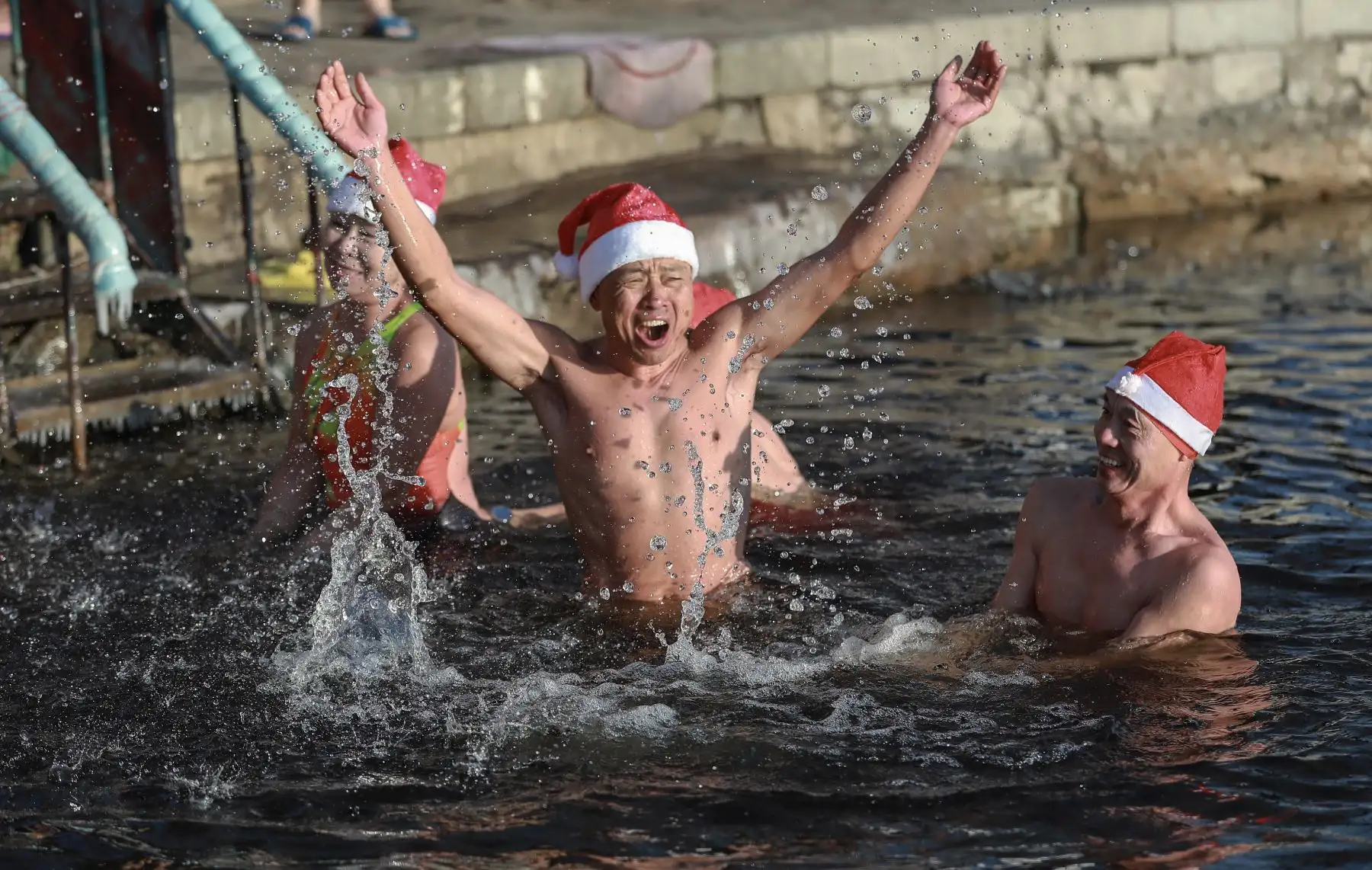 Los entusiastas de la natación de invierno que usan sombreros de Papá Noel nadan en un lago parcialmente congelado a temperaturas de menos 21 grados Celsius (-6 F) en Shenyang, en la provincia de Liaoning, noreste de China. AFP