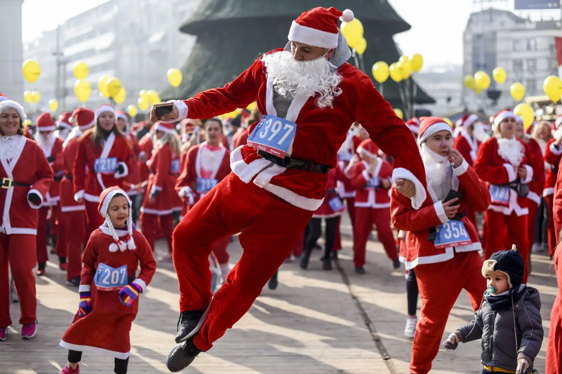 La gente vestida como Santa Claus baila y se prepara para la carrera anual de la ciudad en Skopje. Unos cientos de personas disfrazadas de Santa Claus participaron en una carrera antes del Año Nuevo por las calles de Skopje. AFP