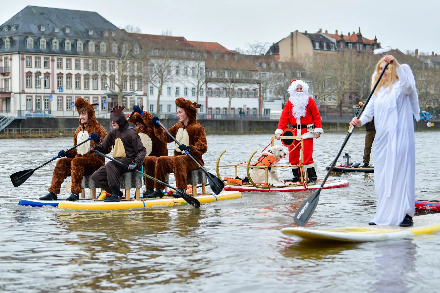 Los remeros de pie vestidos como Santa Claus, renos y un ángel, cruzan el río Neckar en Heidelberg, en el suroeste de Alemania. AFP