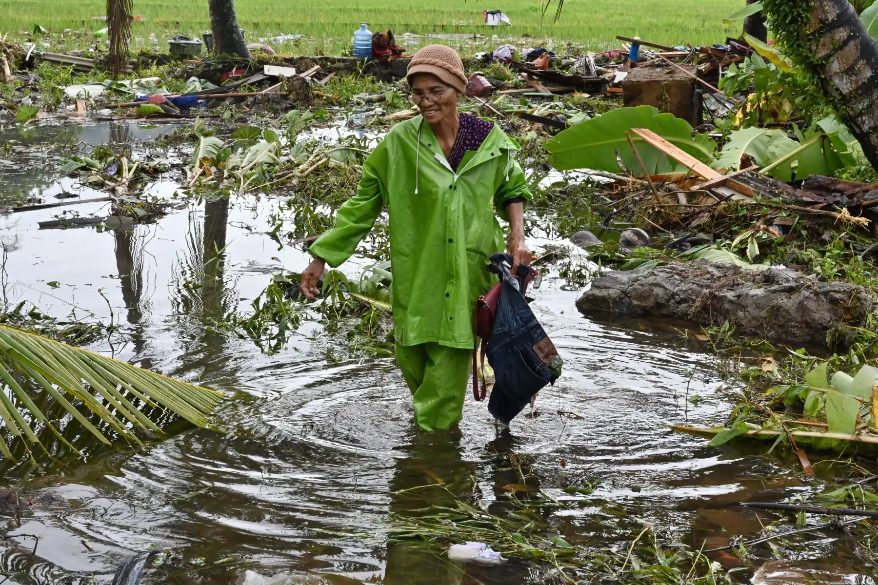Una mujer indonesia recoge artículos de una casa dañada en Carita, provincia de Banten, dos días después de un tsunami, causado por la actividad en un volcán conocido como el "niño" de Krakatoa, que azotó la costa oeste de la isla de Java en Indonesia.  AFP