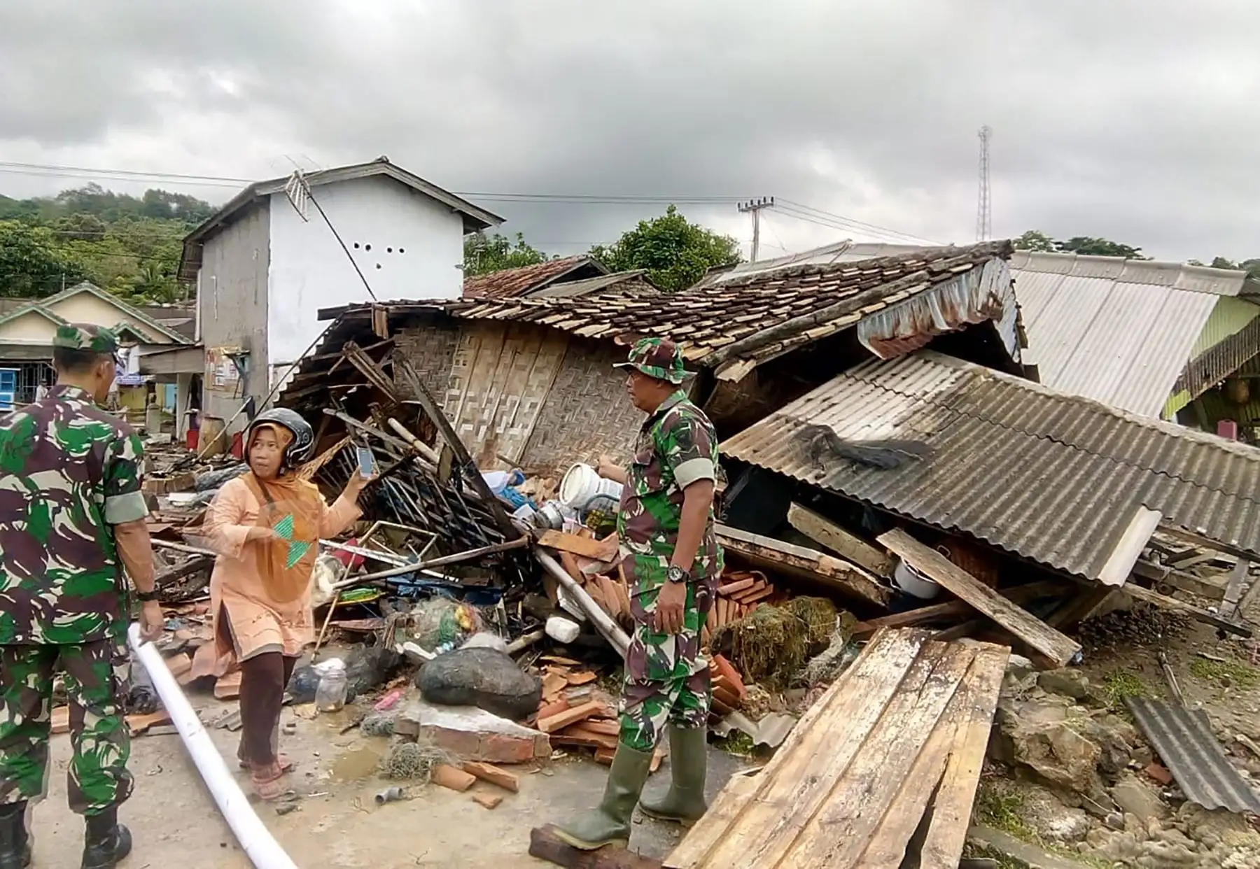 Rescatistas que buscan víctimas entre los edificios dañados por el tsunami en Carita.  AFP