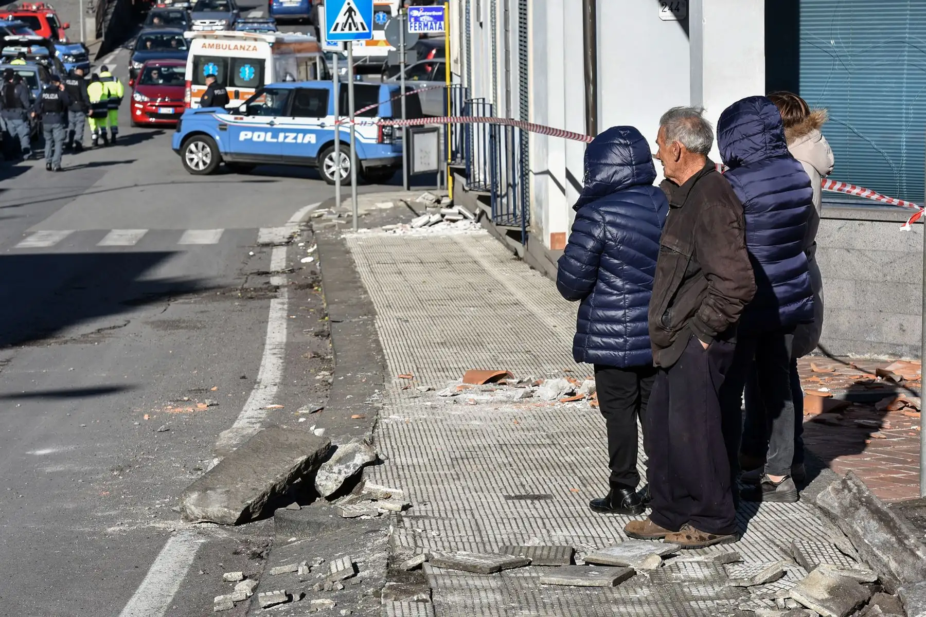 Residentes observan a la policía y al personal de primeros auxilios que intervienen en Zafferana Etnea cerca de Catania, después de que un terremoto de magnitud 4,8 azotara el área alrededor del volcán más activo de Europa, el Monte Etna. AFP