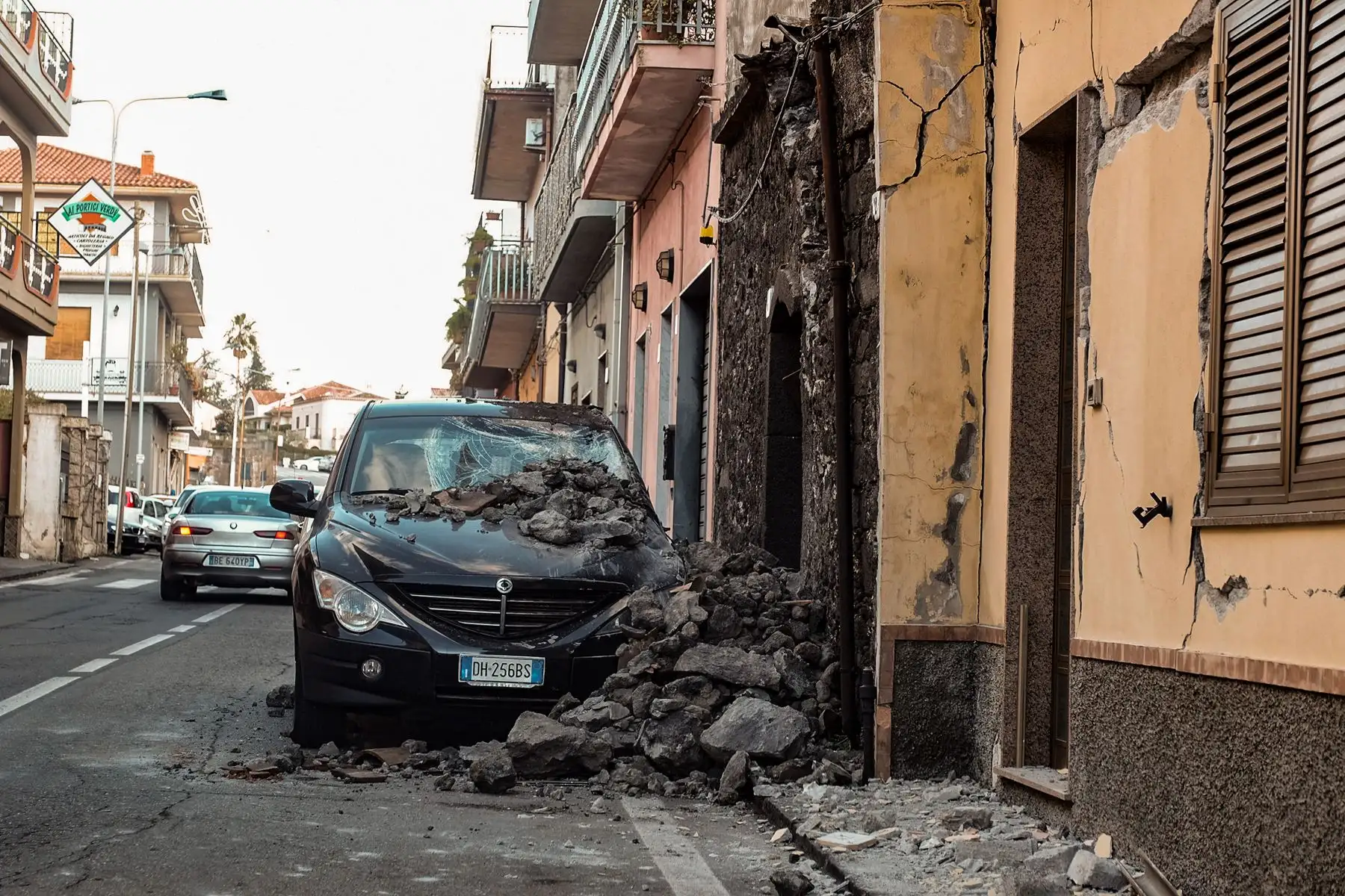 Una pared colapsada y un automóvil dañado se muestran en Zafferana Etnea cerca de Catania. AFP