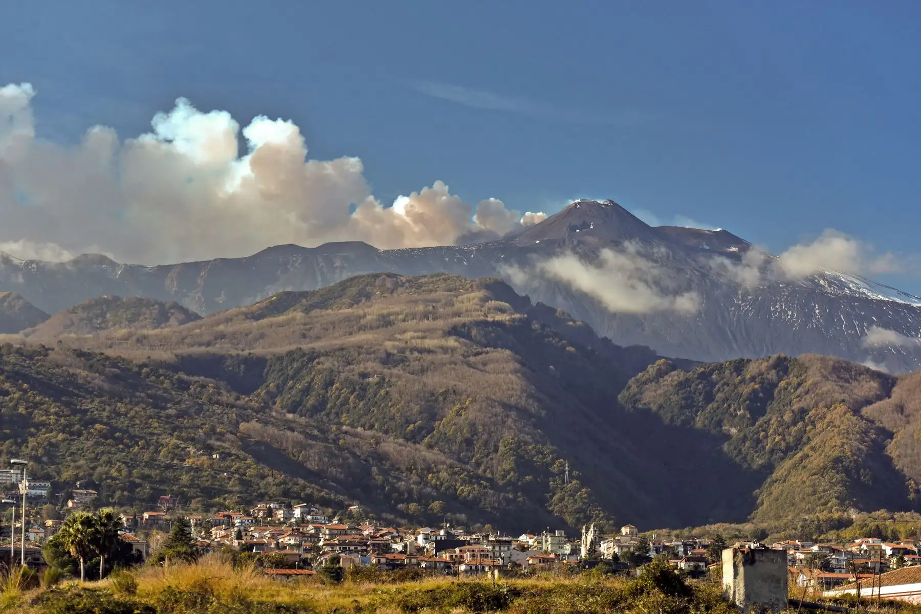 El humo se eleva desde el Monte Etna sobre la ciudad de Giarre, Catania,  Un terremoto de magnitud 4.8 se produjo en el área cerca del volcán más activo de Europa, el Monte Etna, hiriendo a varias personas, dañando edificios y forzando la parcial Cierre de una carretera, dijeron las autoridades italianas de protección civil. AFP
