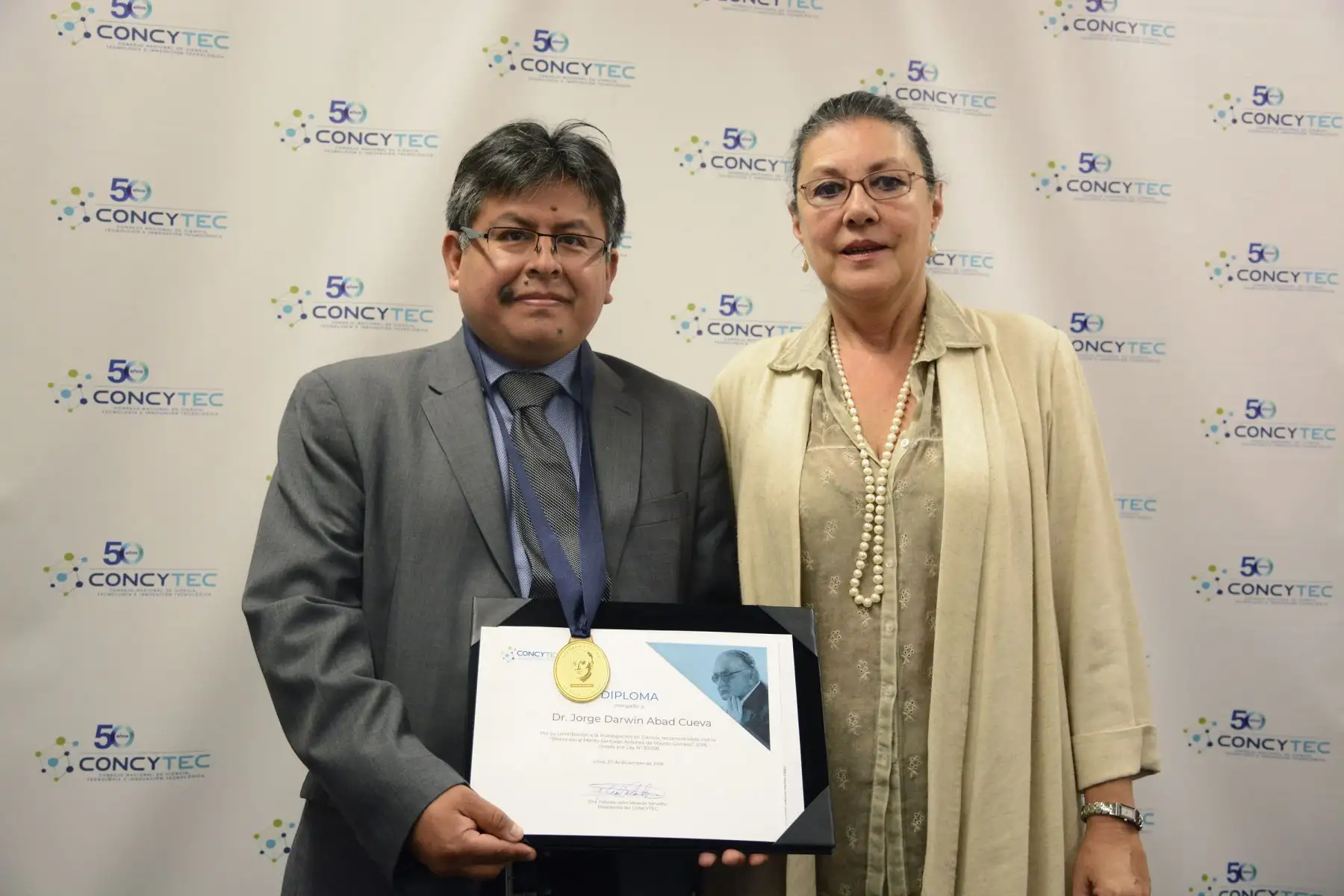 La presidenta de Concytec, Fabiola León-Velarde, otorga distinción al investigador científico Jorge Darwin Abad Cueva.