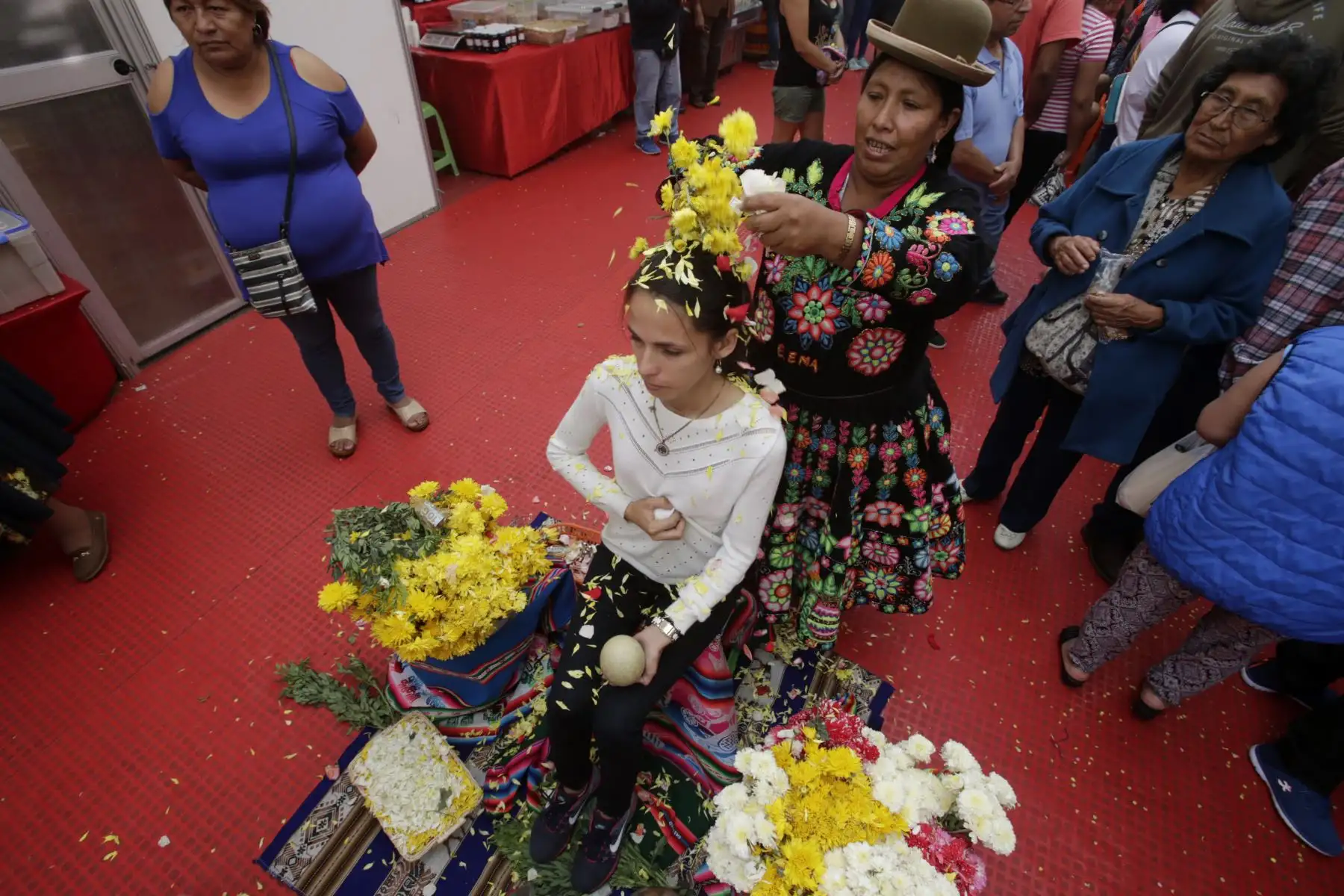 Joven participa en el ritual de florecimiento para alejar energías negativas y estancadas. Foto: ANDINA/Nathalie Sayago