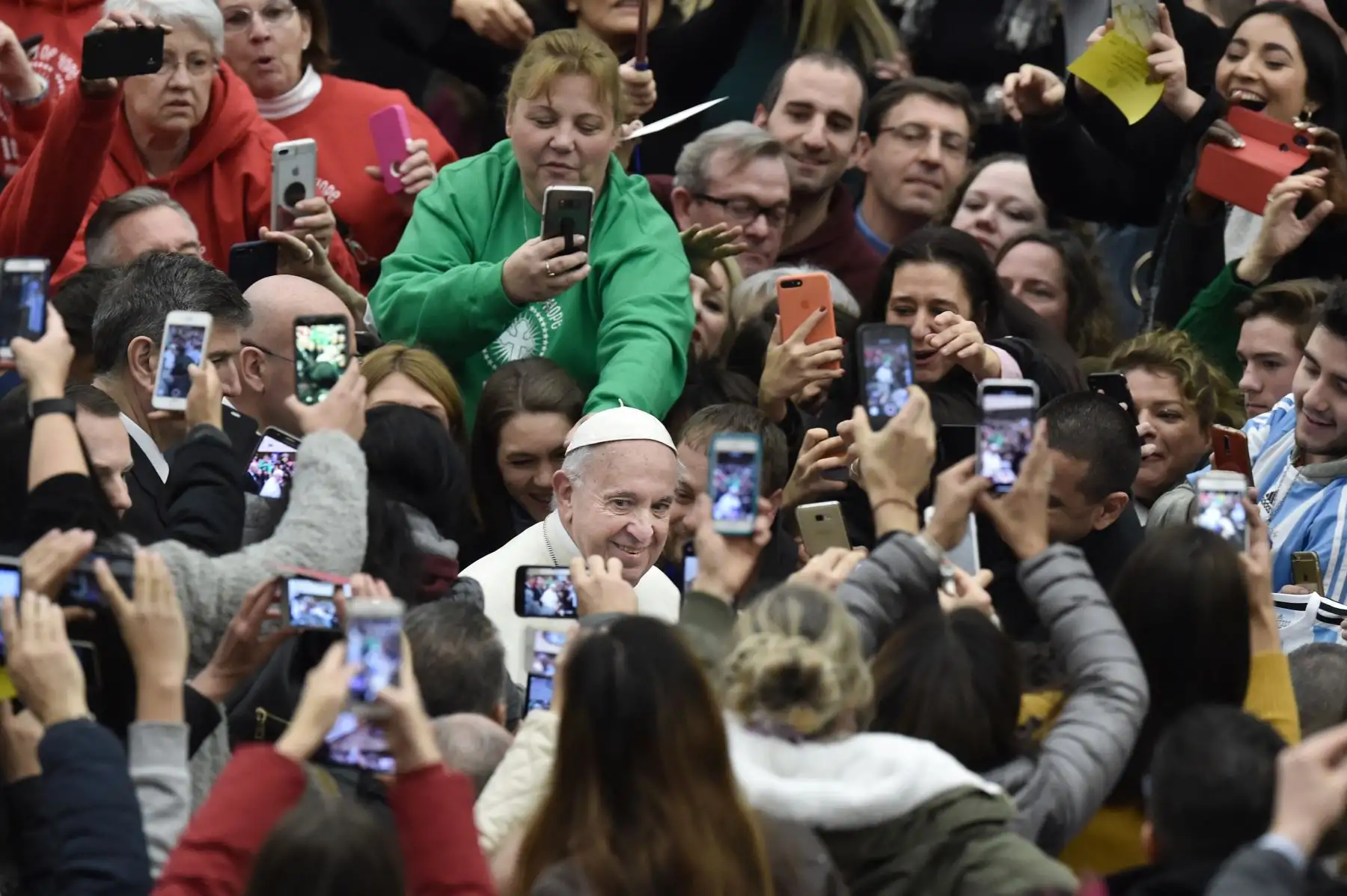 Los fieles toman fotos del Papa Francisco  cuando llega para la audiencia general semanal en el salón Pablo VI. AFP