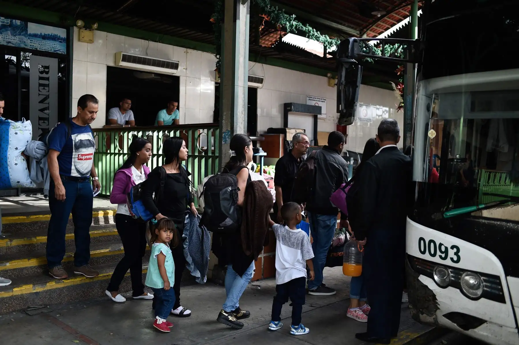 La gente hace cola para abordar un autobús en una estación en Caracas Foto: AFP