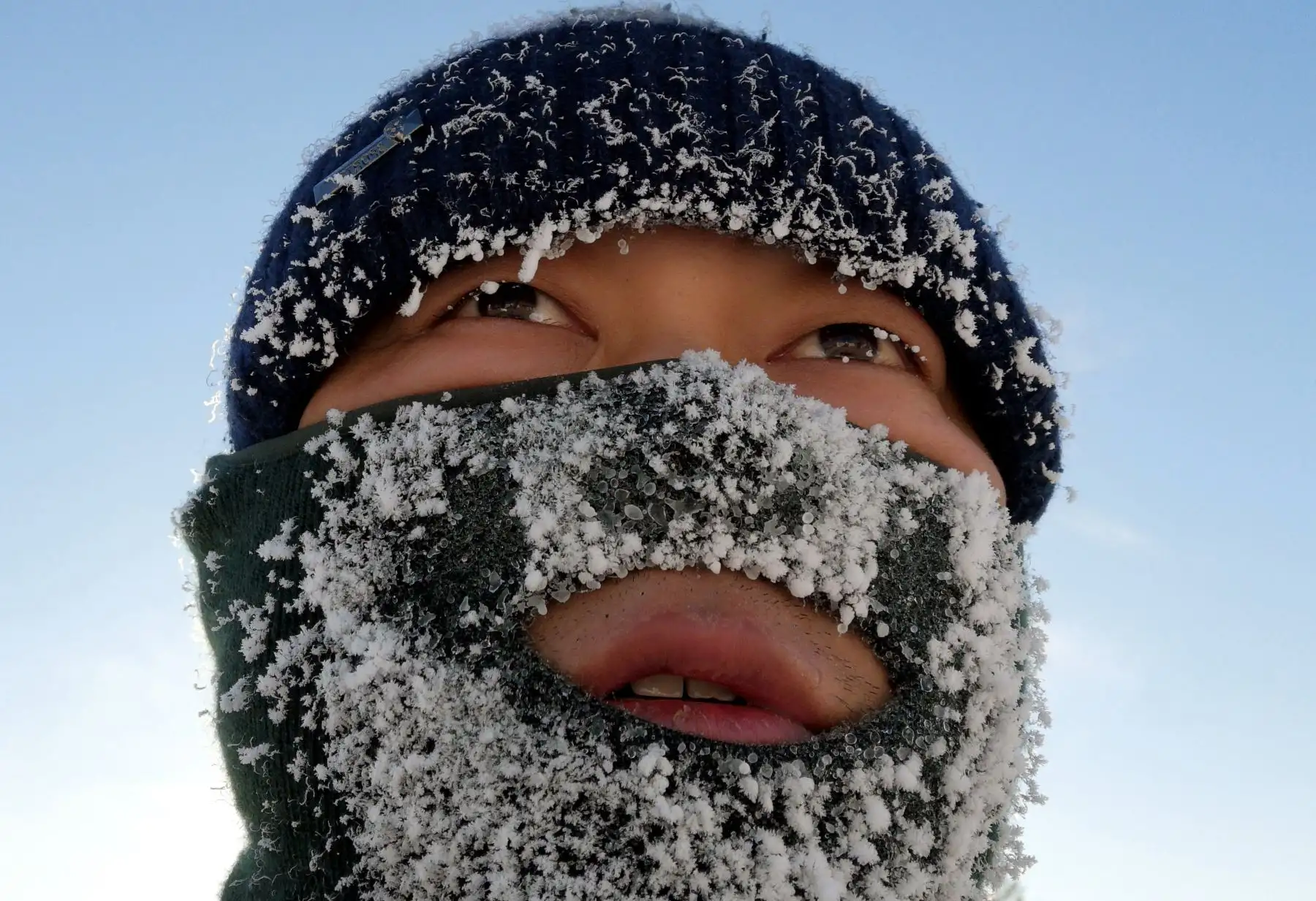 Trabajador que se toma un descanso de tallar una escultura de  nieve en preparación para la temporada de turismo de invierno en Mohe, noreste de China.  La región, en la parte más al norte de China, ve temperaturas tan bajas como -40 C en invierno. Foto: AFP