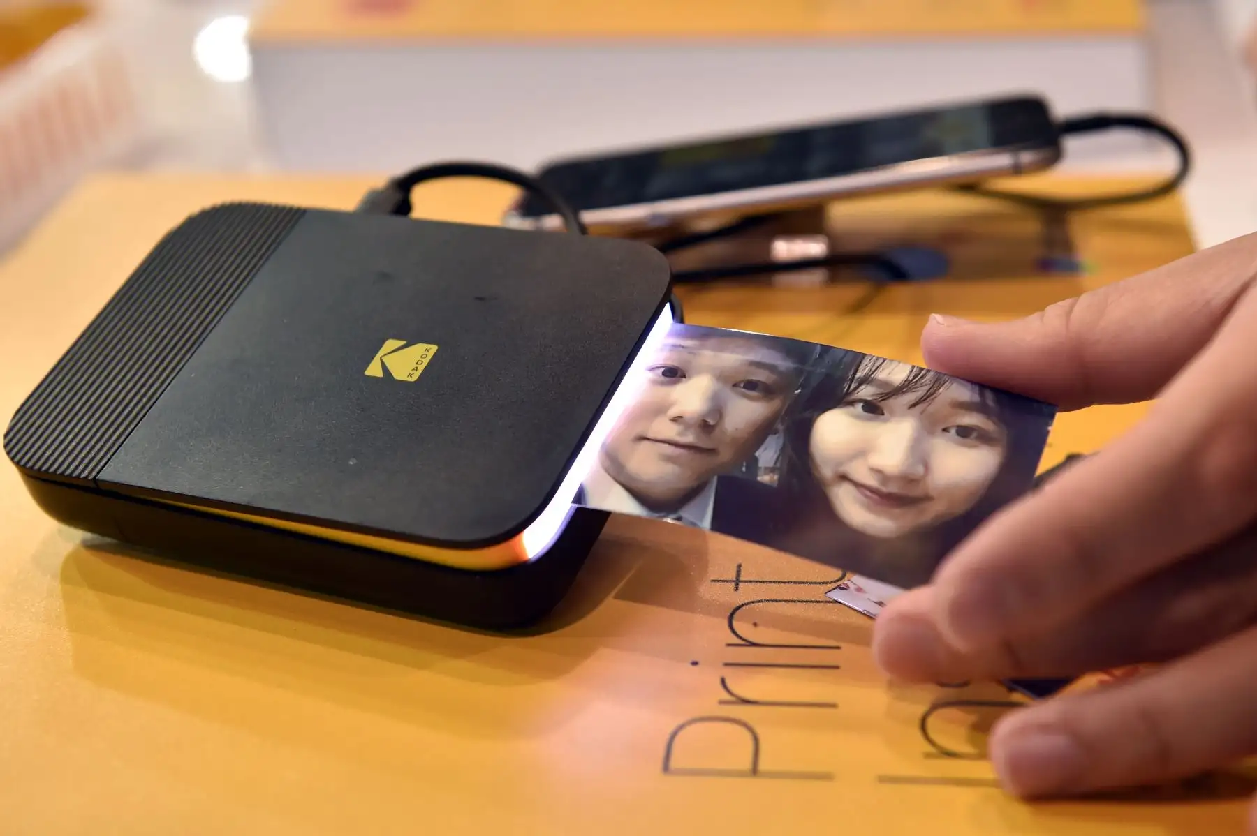 Un asistente saca una fotografía de una impresora instantánea Kodak en el stand de Kodak durante el CES 2019. AFP