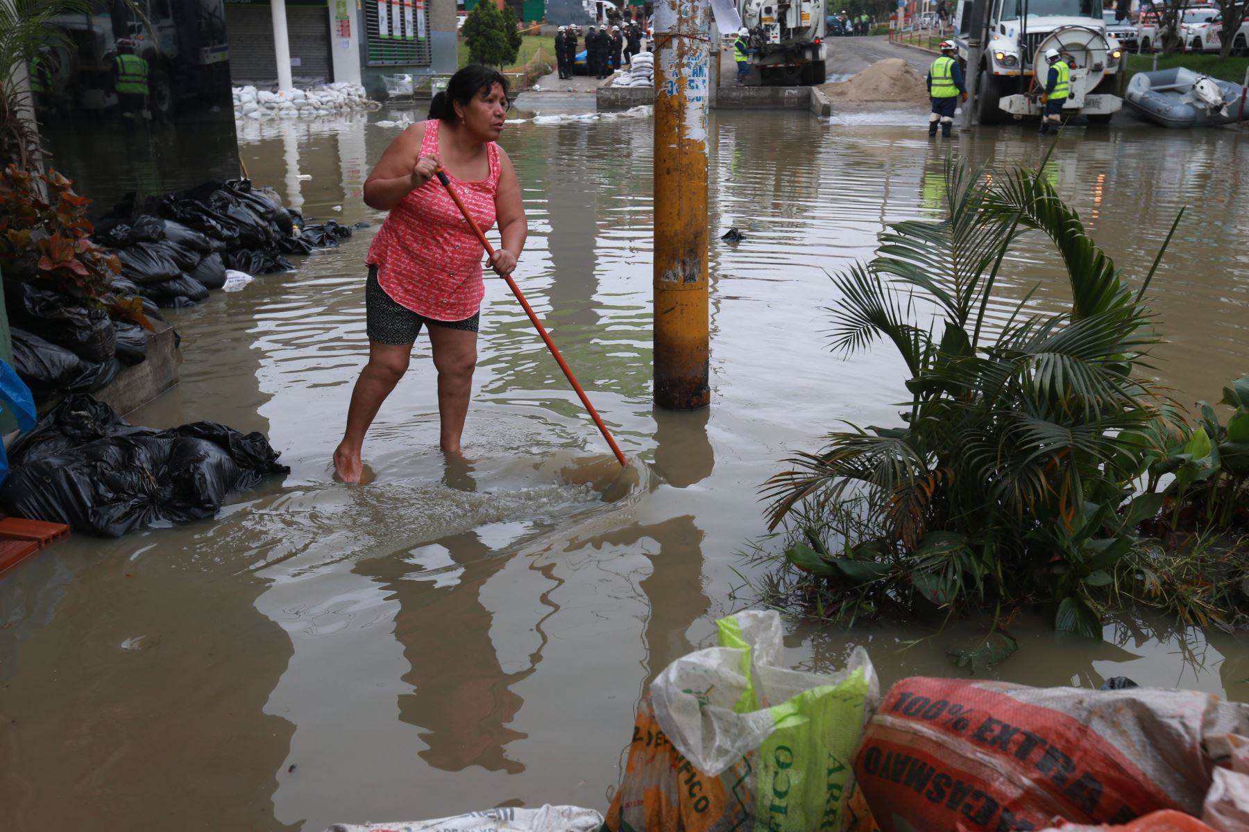 Una pobladora afectada por la inundación intenta alejar el agua servida de su vivienda. Foto: ANDINA/Norman Córdova