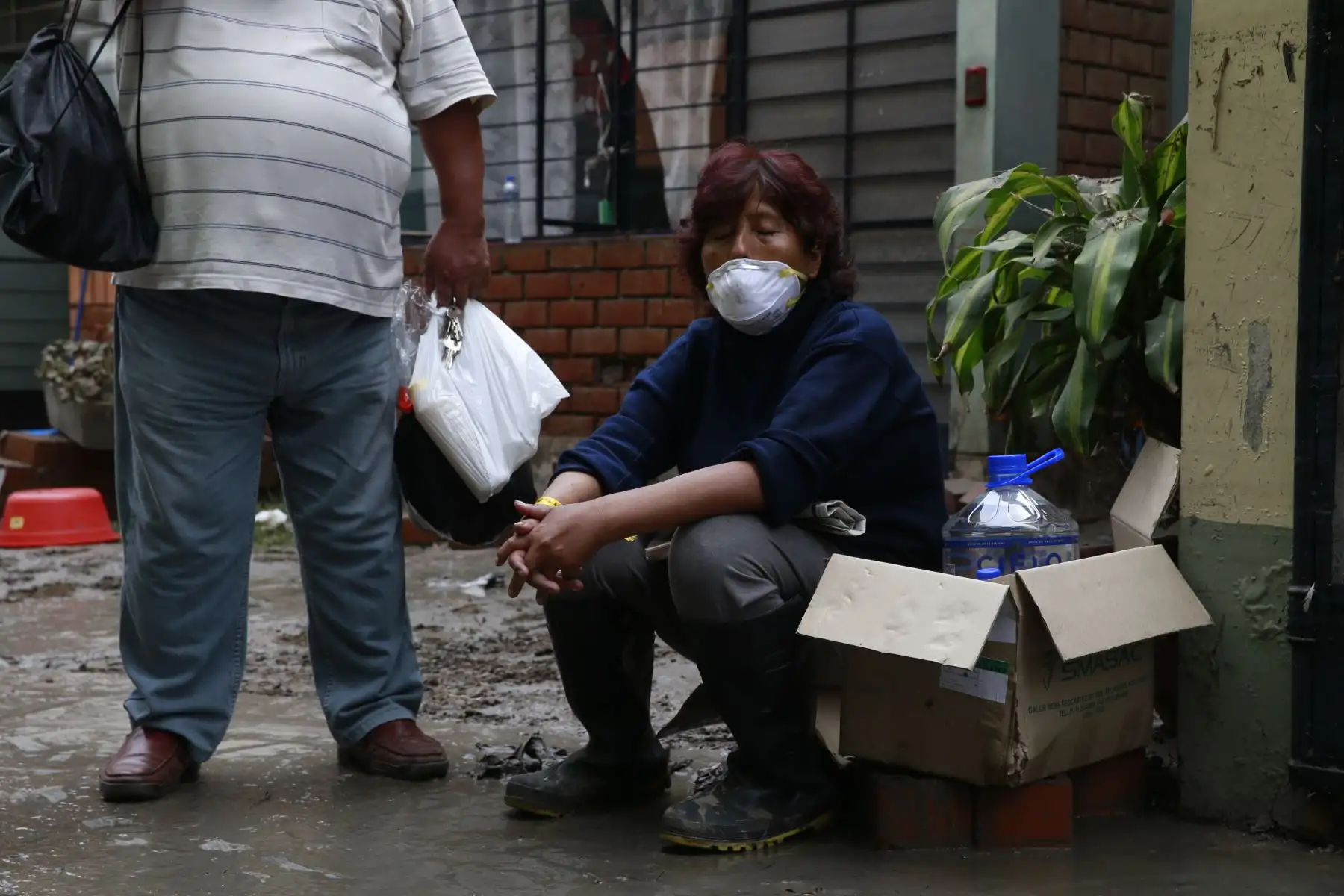 Vecina descansa a las afueras de su casa mientas que se realizan las labores de limpieza en la zona del aniego en San Juan de Lurigancho. Foto: ANDINA/Nathalie Sayago