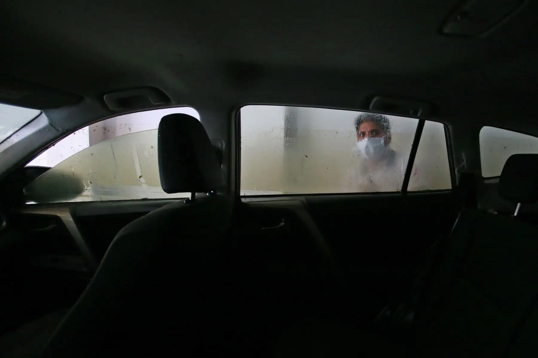 Propietario inspecciona los daños en su vehículo a causa del aniego en San Juan de Lurigancho. Foto: ANDINA/Nathalie Sayago