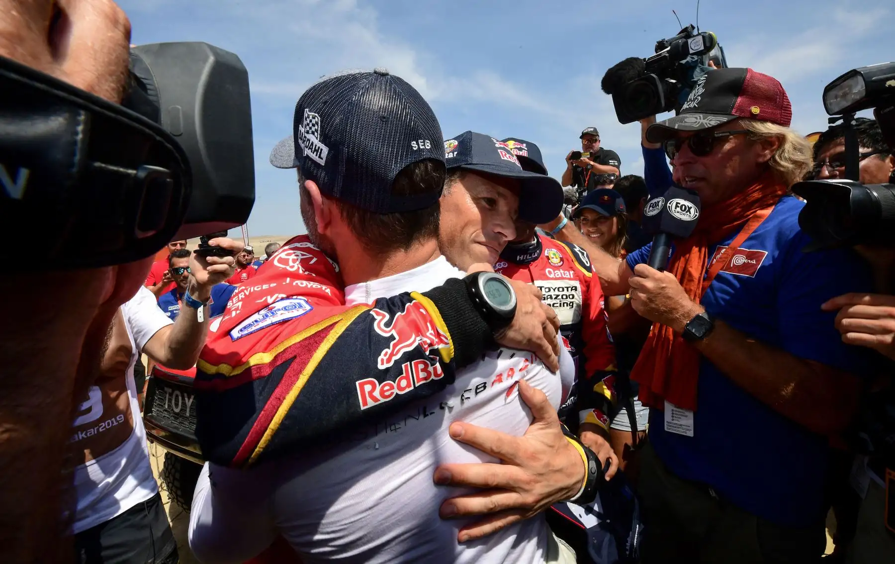El copiloto de Toyota Matthieu Baumel (C) de Francia es felicitado por el piloto francés de Peugeot, Sebastien Loeb (al revés), luego de ganar el Rally Dakar 2019, al final de la última etapa entre Pisco y Lima, en Pisco. AFP