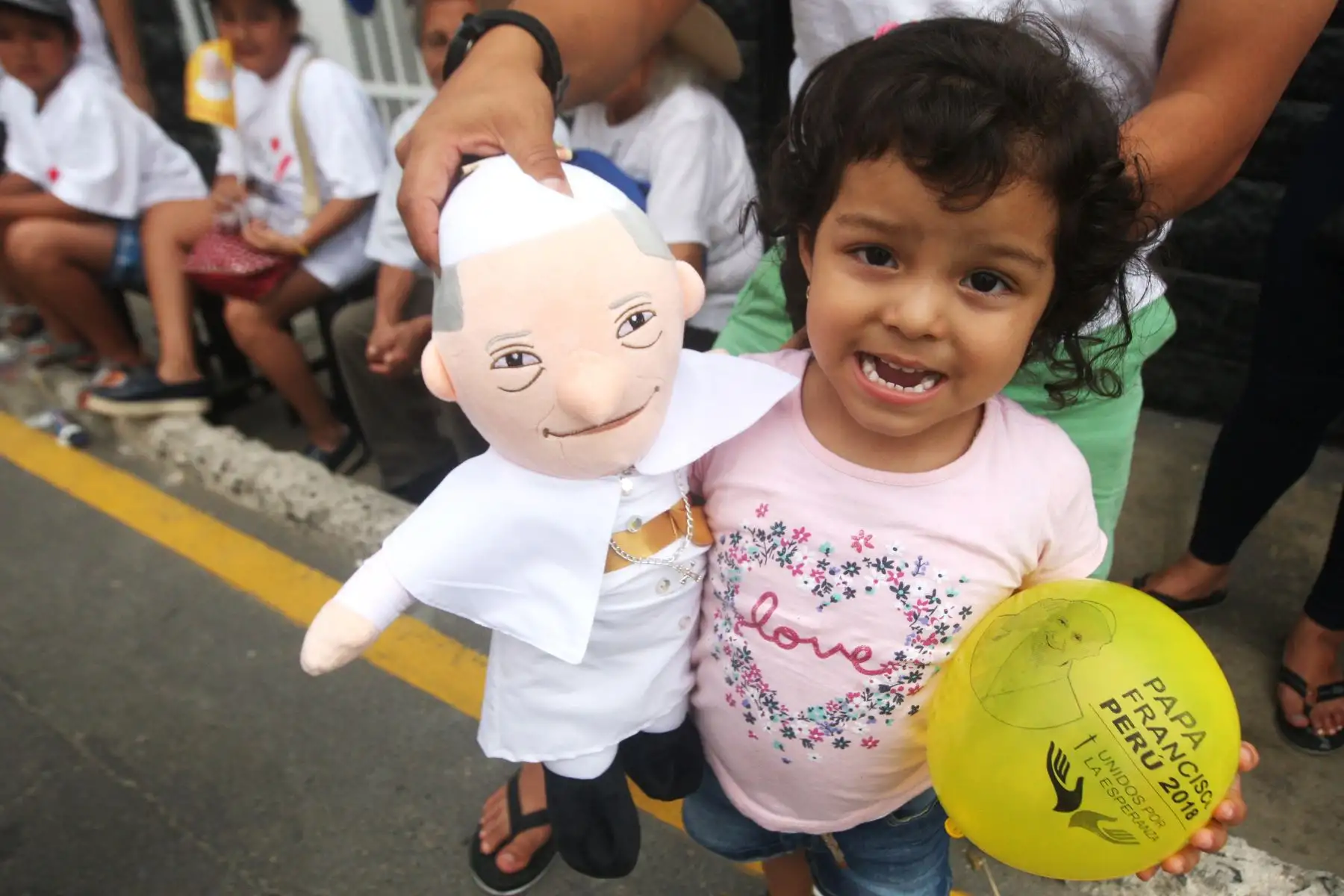 Niña con un muñeco del Papa Francisco, mientras espera su paso en la av. Colonial. Foto: ANDINA/Hector Vinces