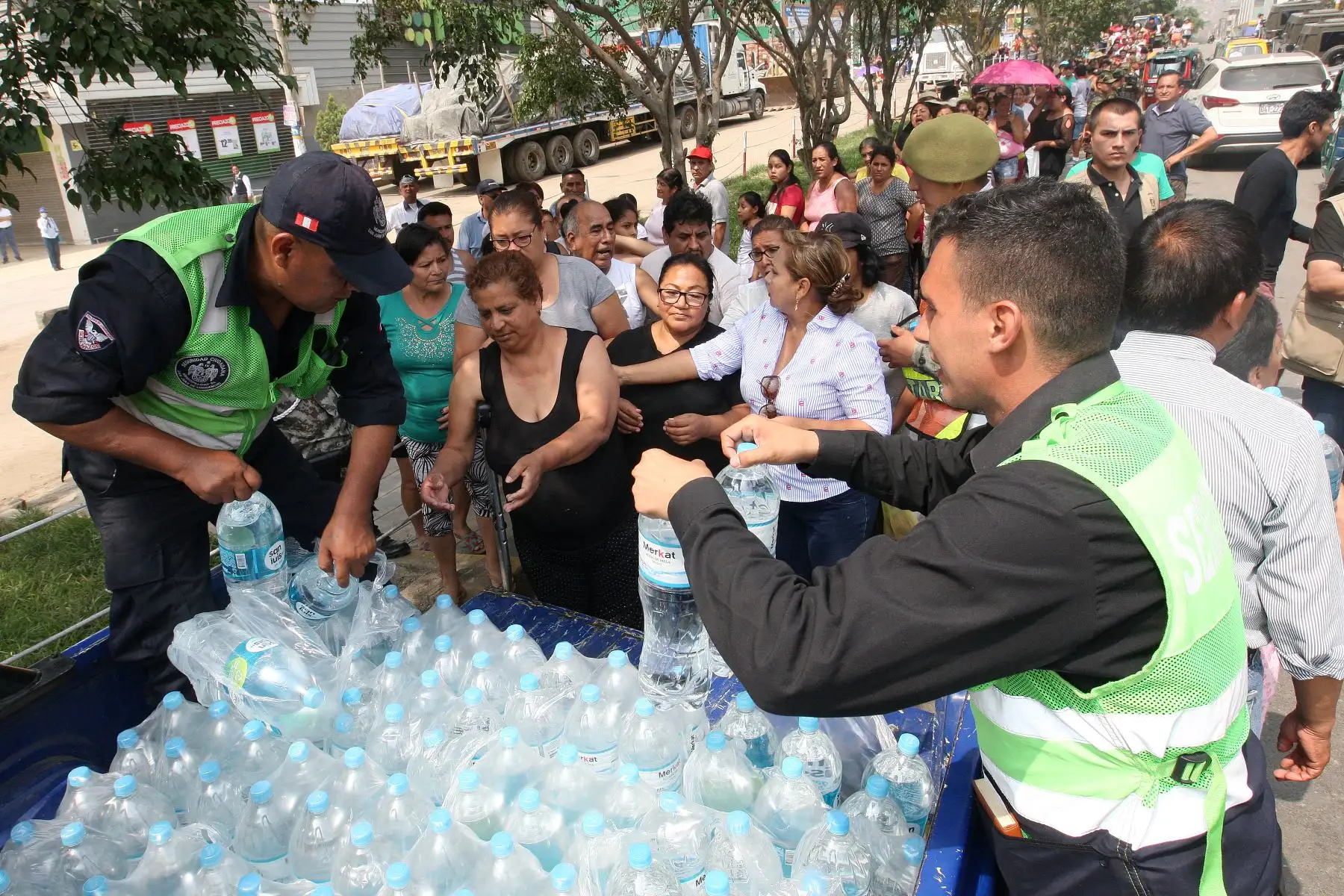 Miembros de FF.AA. reparten agua a vecinos afectados por aniego casa por casa.Foto:ANDINA/Héctor Vinces.