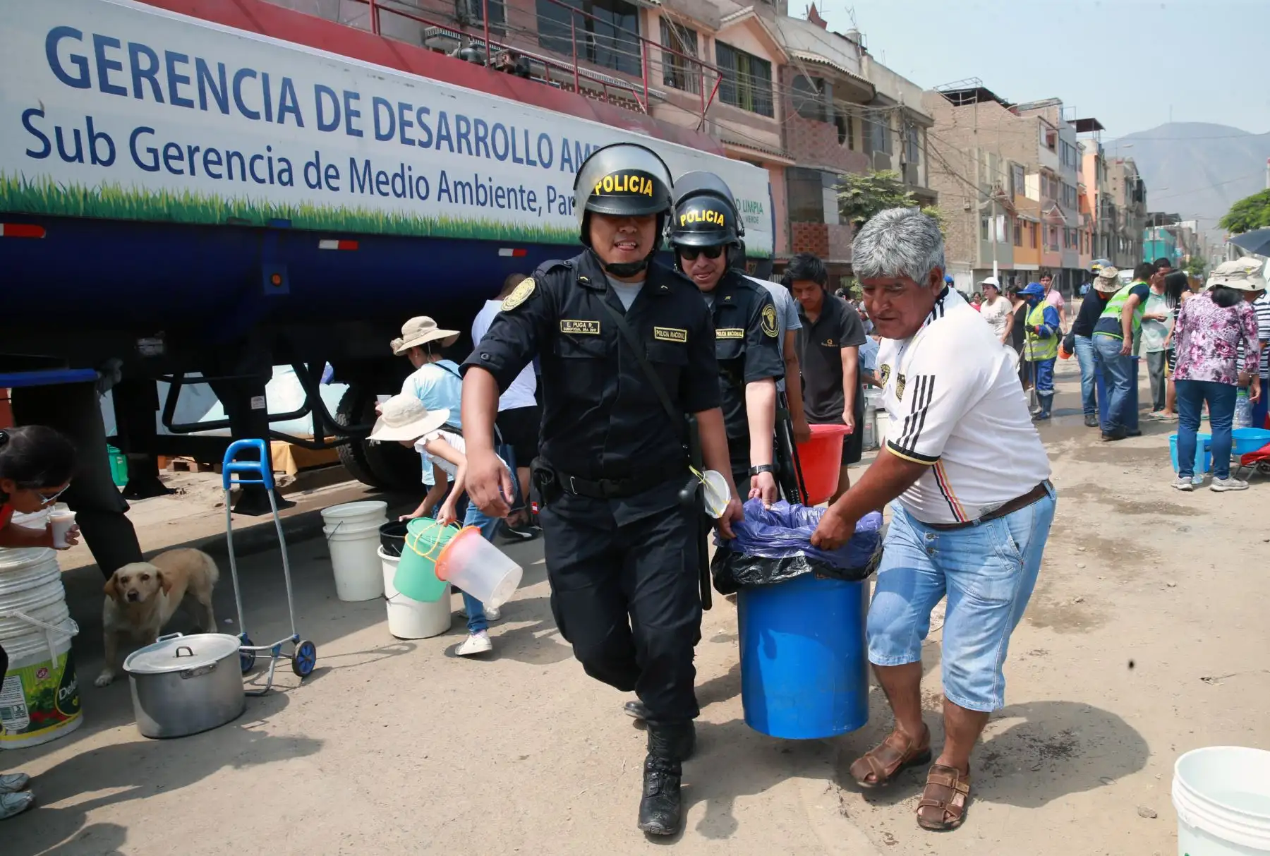 Policía nacional apoya con distribución de agua potable a vecinos afectadas por el aniego, en San Juan de Lurigancho. Foto: ANDINA/Norman Córdova
