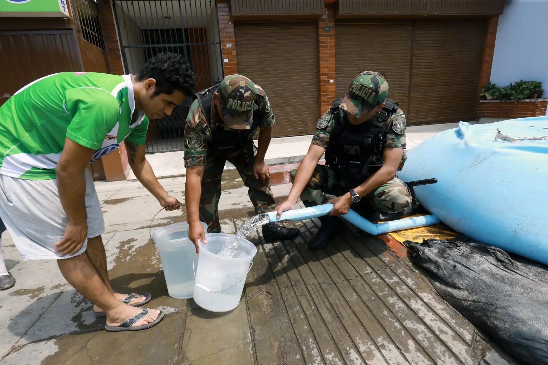 Policía nacional apoya con distribución de agua potable a vecinos afectadas por el aniego, en San Juan de Lurigancho. Foto: ANDINA/Norman Córdova