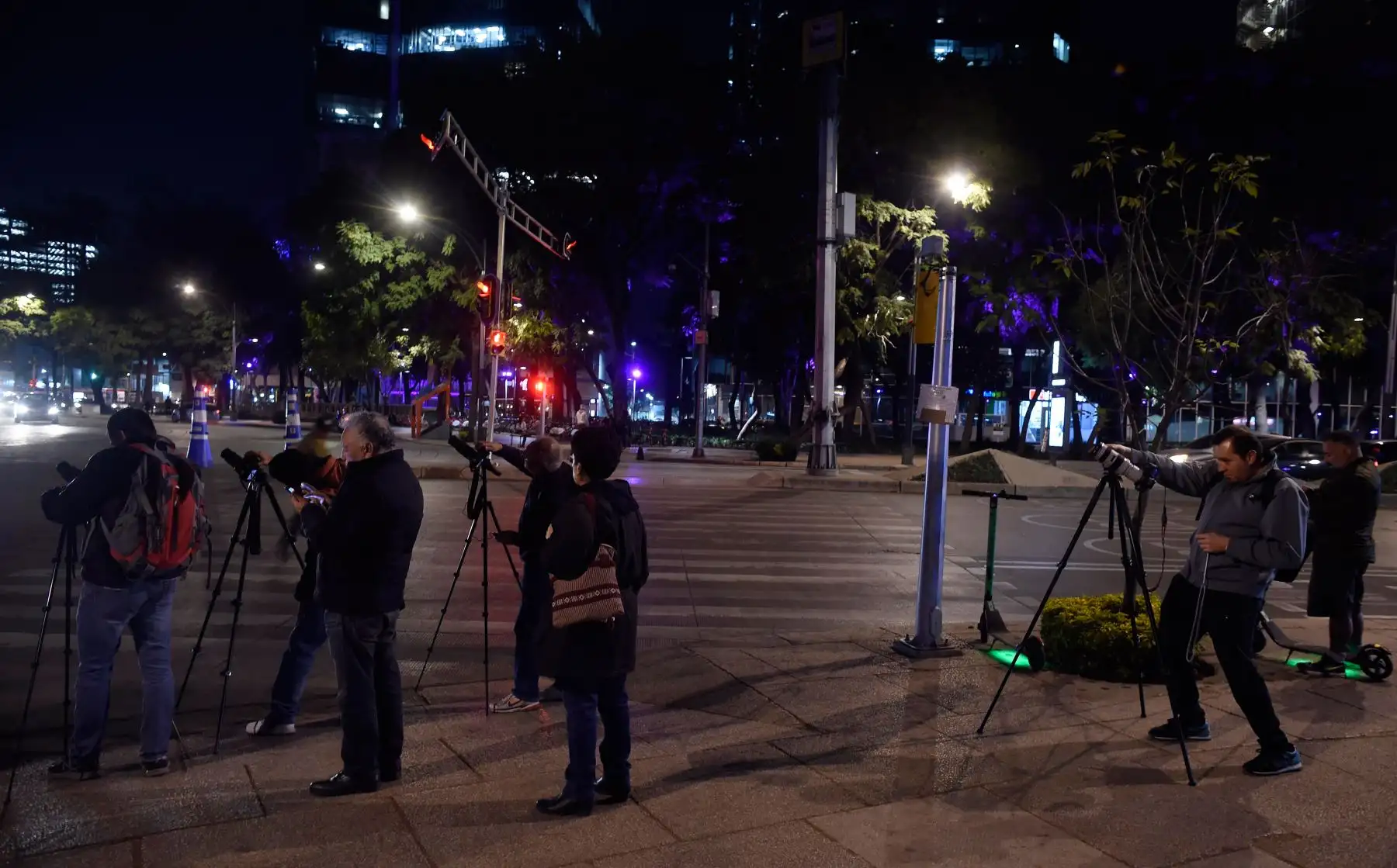 La gente toma fotografías de la Súper Luna durante el inicio del eclipse lunar total, en el Ángel de la Independencia en la Ciudad de México el 20 de enero de 2019.