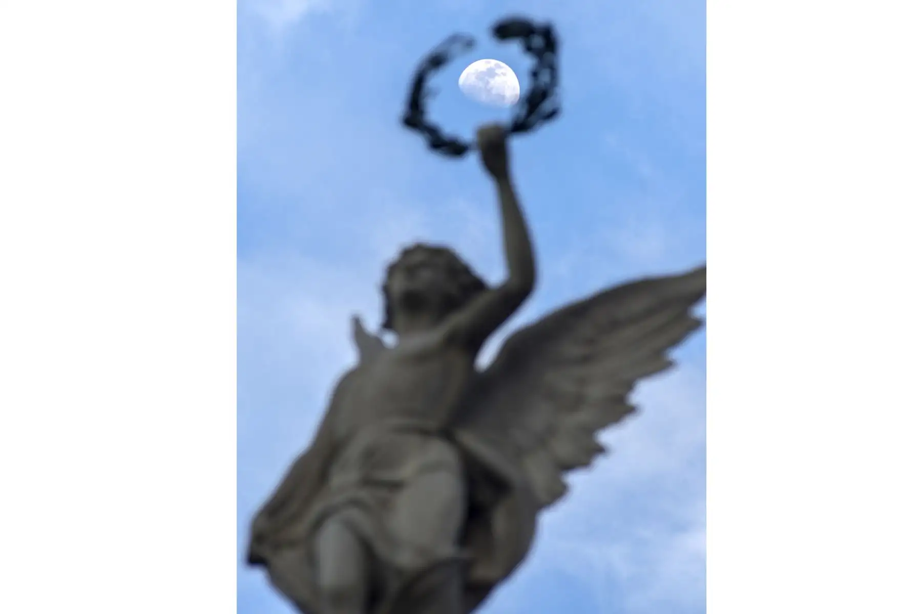 La luna se levanta sobre la escultura "Fama" en la fachada del Teatro Nacional en San José, Costa Rica. Foto.AFP