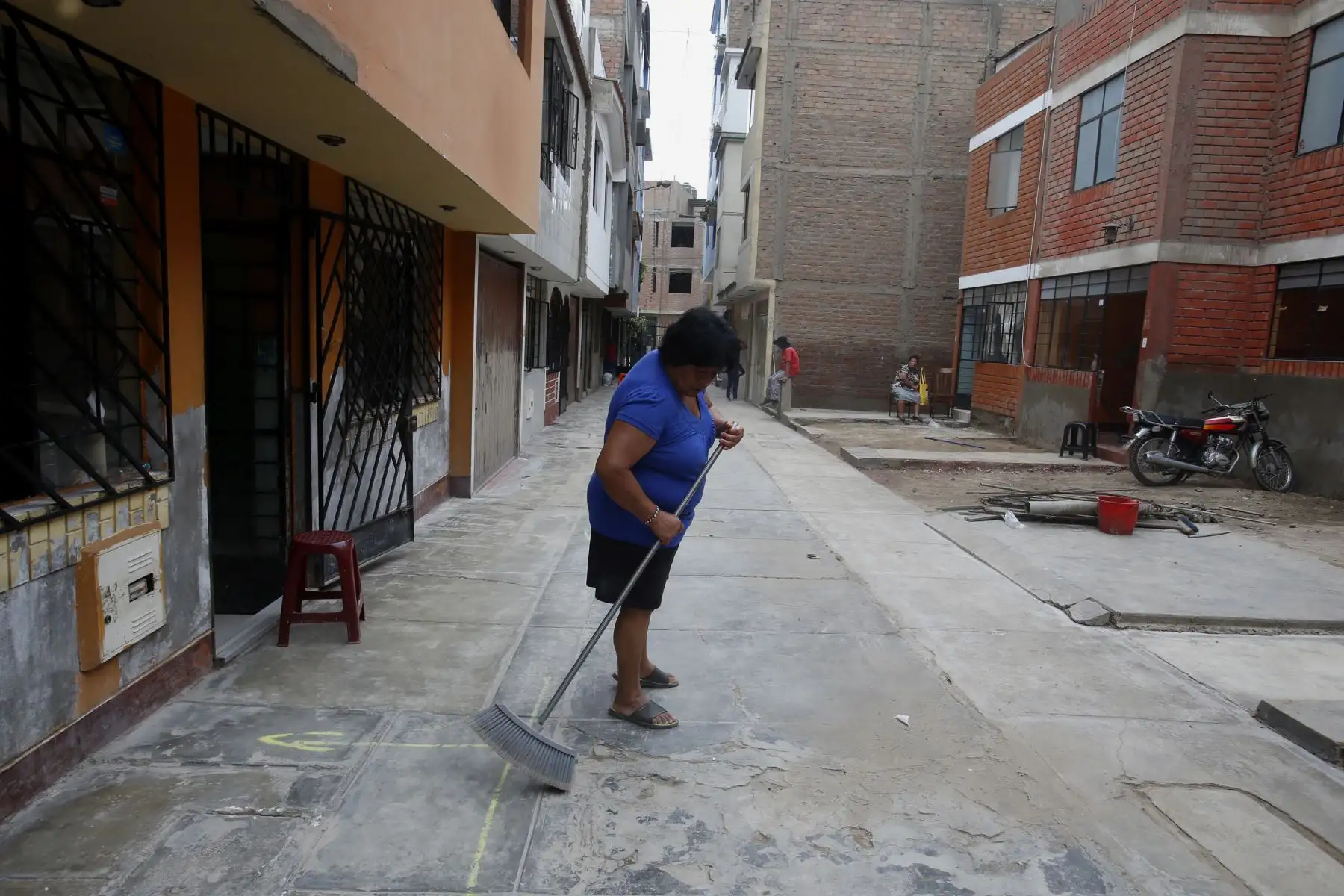Propietaria limpia a las afueras de su casa en la zona del aniego en San Juan de Lurigancho. Foto: ANDINA/Nathalie Sayago