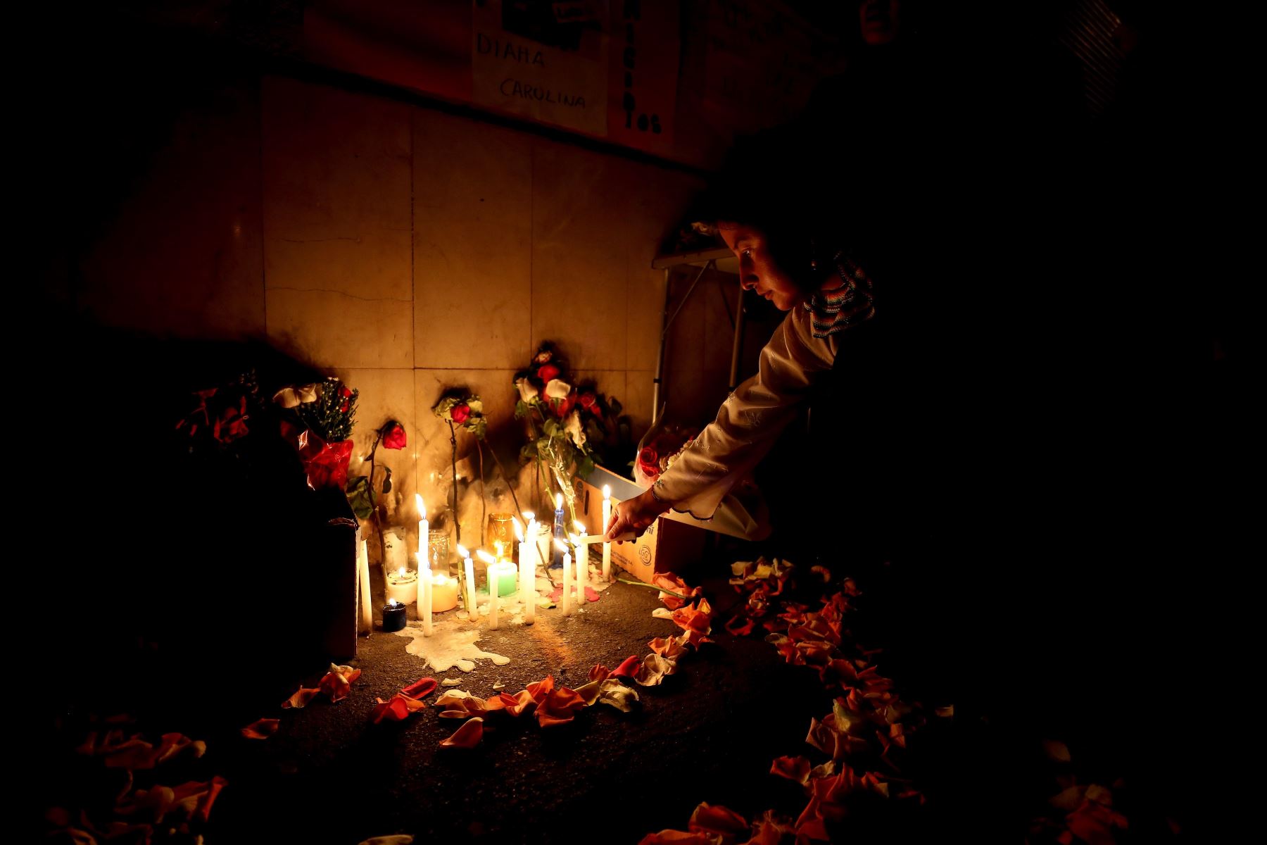 Ciudadanos ecuatorianos levantan un altar en memoria de la mujer que fue asesinada el sábado pasado por su pareja, un venezolano, en la ciudad de Ibarra (Ecuador). El asesinato desató la reacción xenófoba de una turba. Foto: EFE