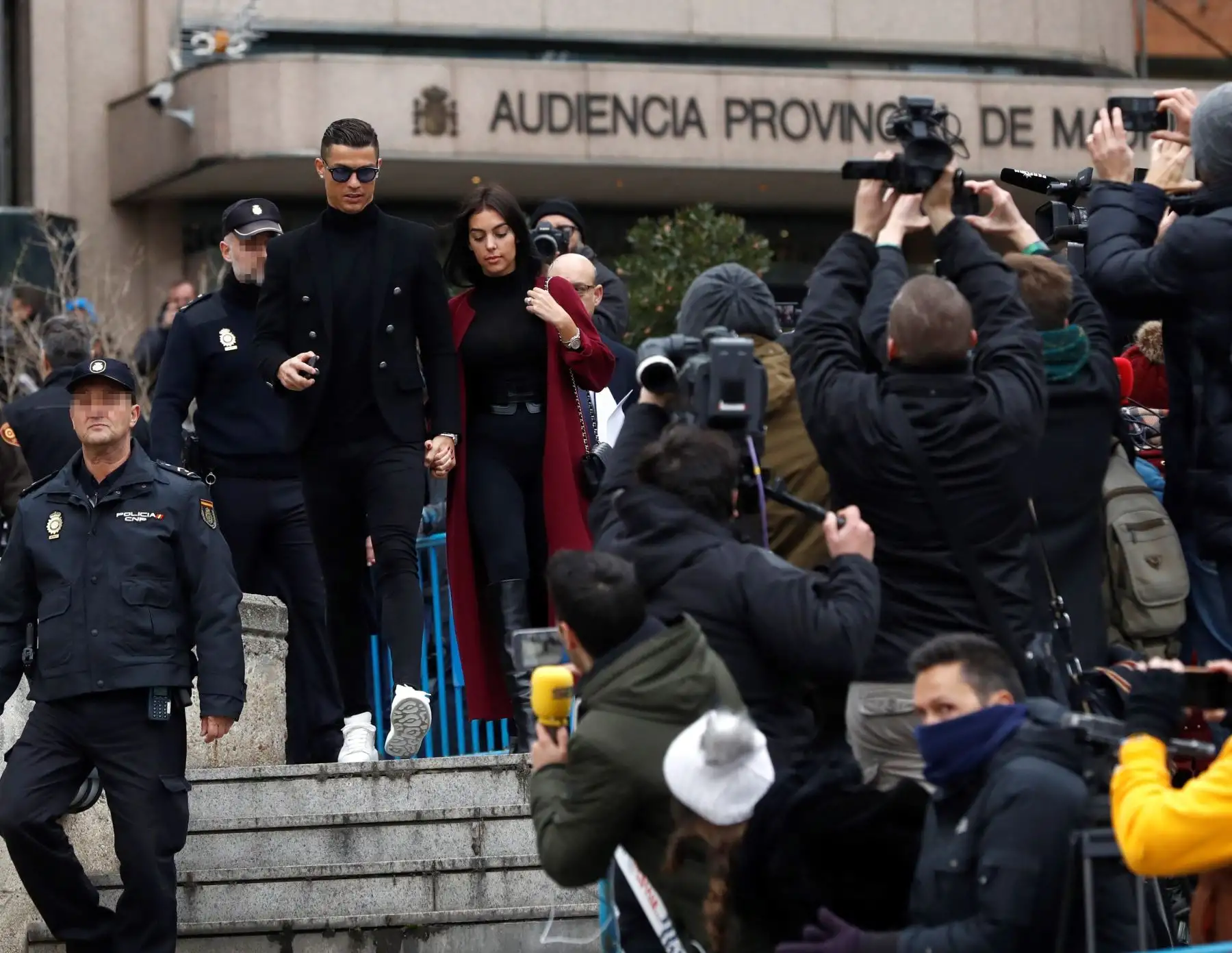 El exjugador del Real Madrid Cristiano Ronaldo, junto a su pareja Georgina Rodríguez, a la salida de la Audiencia Provincial de Madrid, en el que fue condenado a 23 meses de prisión -que no cumplirá- y a una multa de 18,8 millones de euros por eludir el pago de 5,7 millones a Hacienda. Foto: EFE