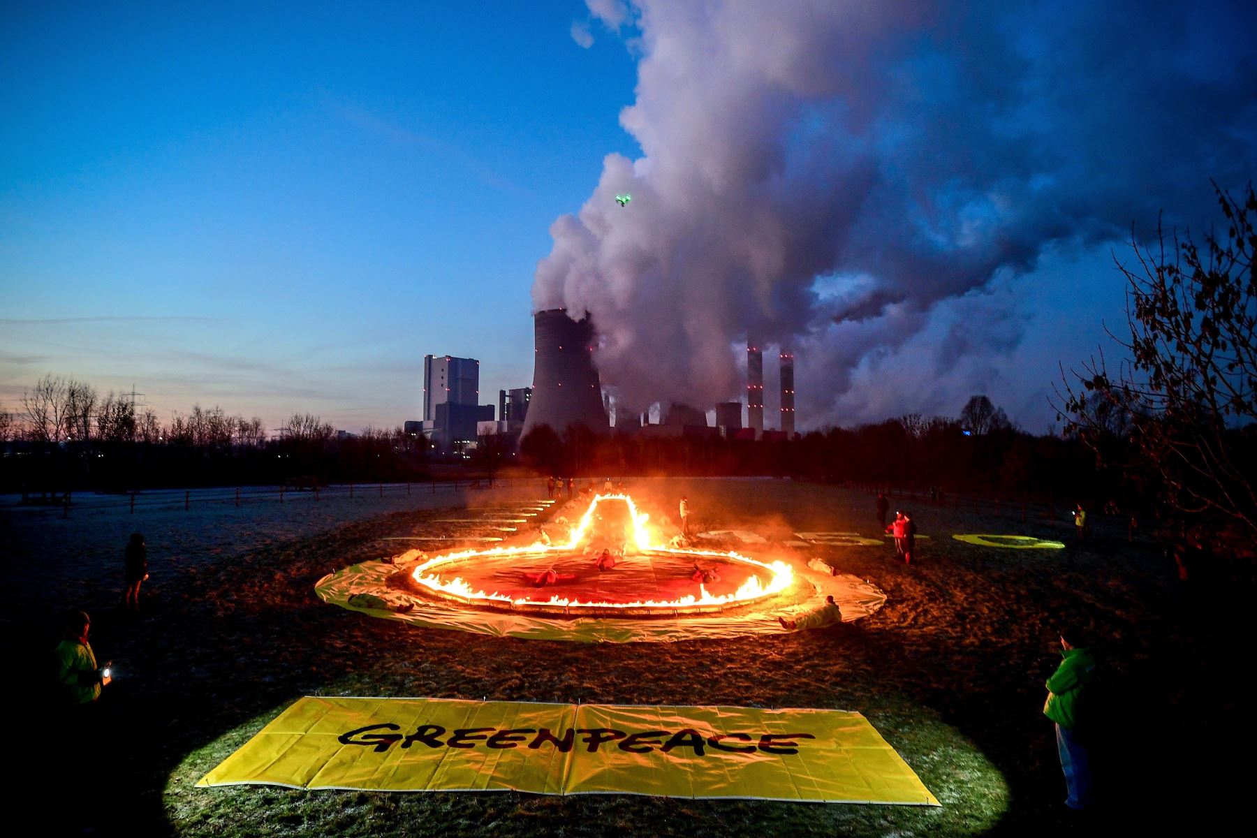 Activistas de Greenpeace dibujan un termómetro con fuego delante de la central térmica de lignito Niederaussem, operada por RWE, en Bergheim (Alemania), para reclamar una mayor protección del clima. Foto: EFE