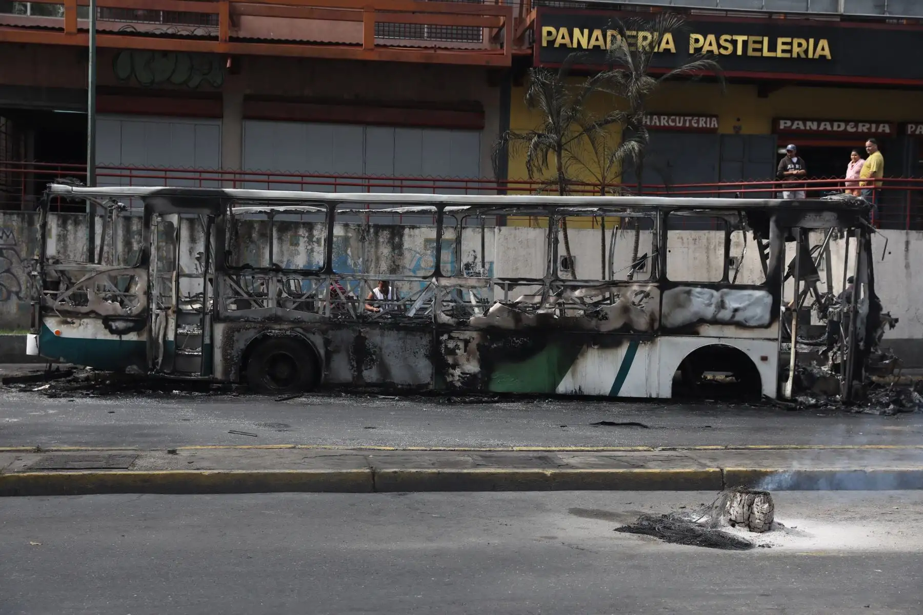Vista de un autobús incendiado en la madrugada de este miércoles en Caracas (Venezuela). Cientos de venezolanos se manifestaron anoche en contra del Gobierno de Nicolás Maduro y expresaron su sentimiento golpeando cacerolas desde el interior de sus casas o saliendo a las calles, especialmente en barriadas de Caracas y el interior del país. EFE