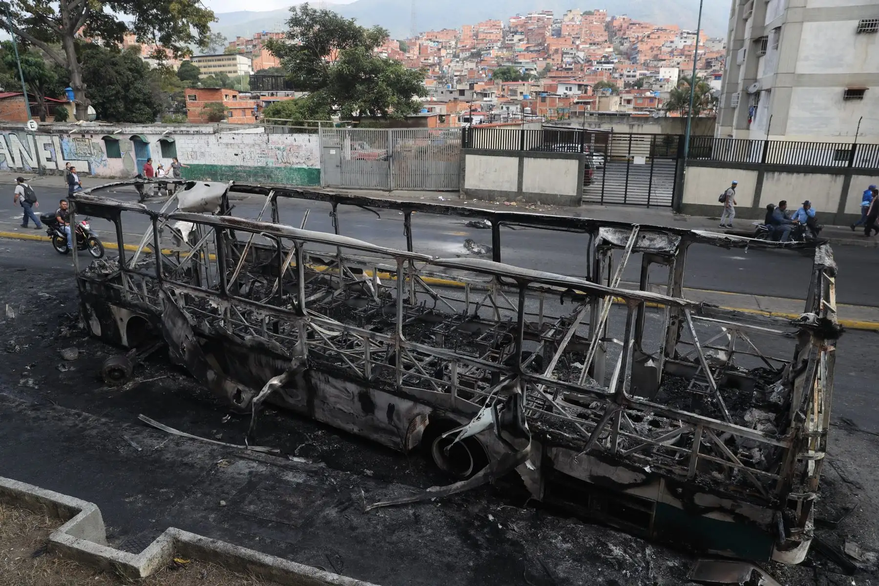 Vista de un autobús incendiado en la madrugada de este miércoles en Caracas (Venezuela). Cientos de venezolanos se manifestaron anoche en contra del Gobierno de Nicolás Maduro y expresaron su sentimiento golpeando cacerolas desde el interior de sus casas o saliendo a las calles, especialmente en barriadas de Caracas y el interior del país. EFE/