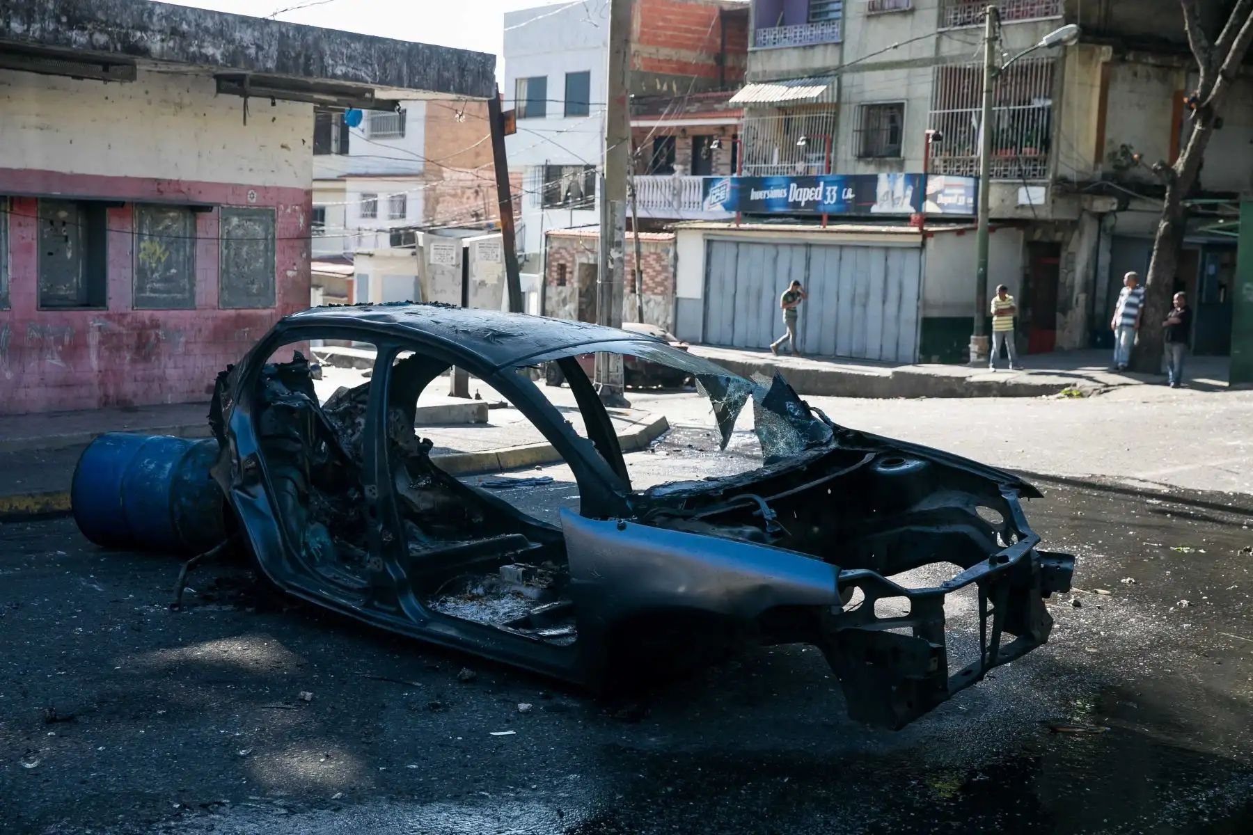 Restos de un vehículo incendiado en una calle donde hubo protestas este martes en Caracas (Venezuela). Al menos una decena de protestas callejeras que se iniciaron anoche en Caracas se han extendido hasta la madrugada de este martes, especialmente en zonas consideradas bastiones del oficialismo, en las que los manifestantes piden el fin del Gobierno de Nicolás Maduro. EFE