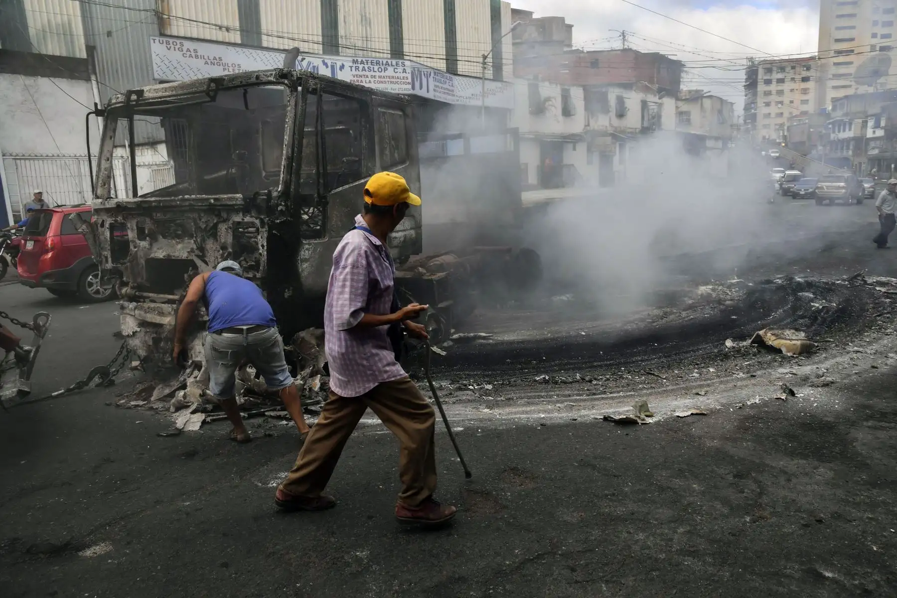 Los trabajadores usan una grúa para mover los restos de un camión que se quemó durante las protestas de la noche anterior en el emblemático vecindario de Petare en Caracas, el 24 de enero de 2019. El jefe de la ONU, Antonio Guterres, pidió el jueves un diálogo para detener la crisis política de Venezuela. Saliéndose de control, el líder opositor Juan Guaido se declaró a sí mismo presidente interino.  AFP