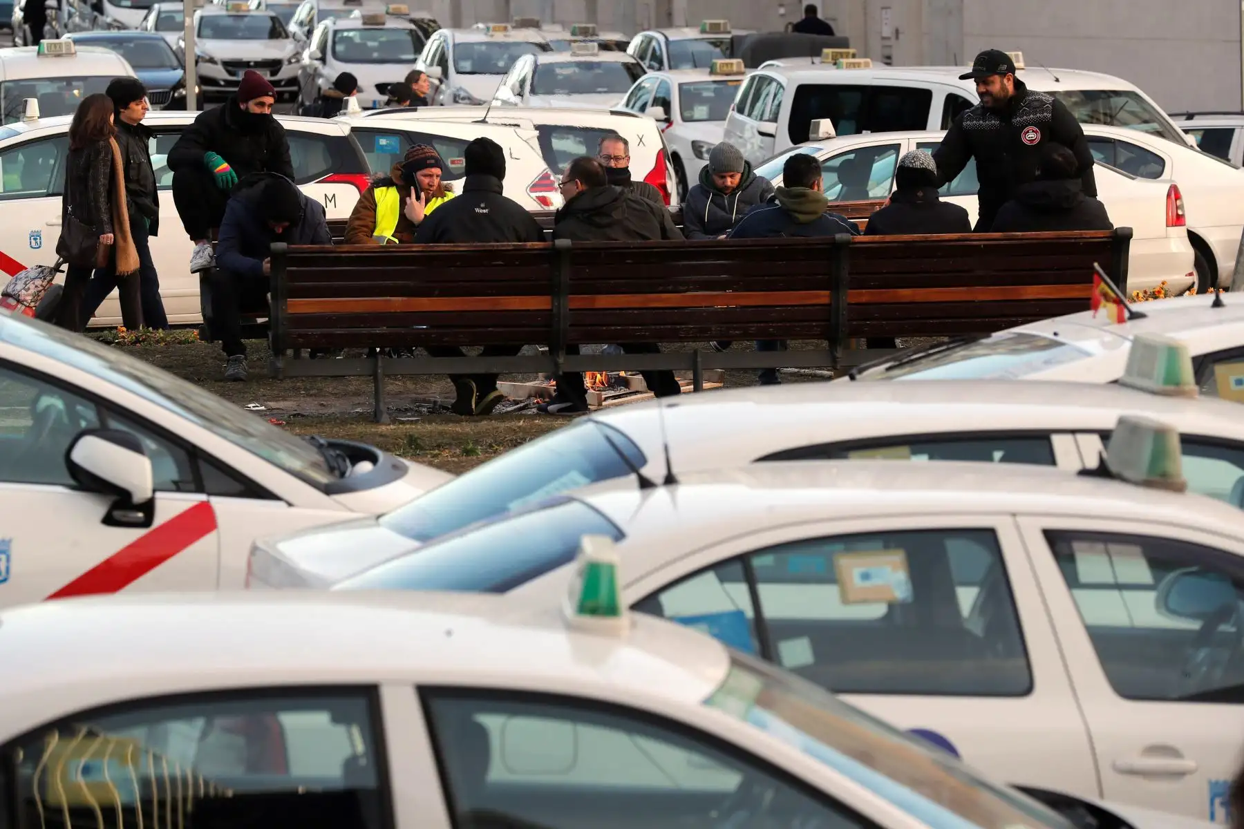 MADRID. Un grupo de taxistas a las puertas del recinto ferial de IFEMA, donde se celebra la feria de turismo, FITUR, durante el cuarto día de huelga del sector del que reclama a la administración autonómica que apruebe una legislación que limite la actividad de las empresas de vehículos de alquiler con conductor (VTC), después de que los taxistas de Barcelona hayan acordado poner fin a la protesta. EFE