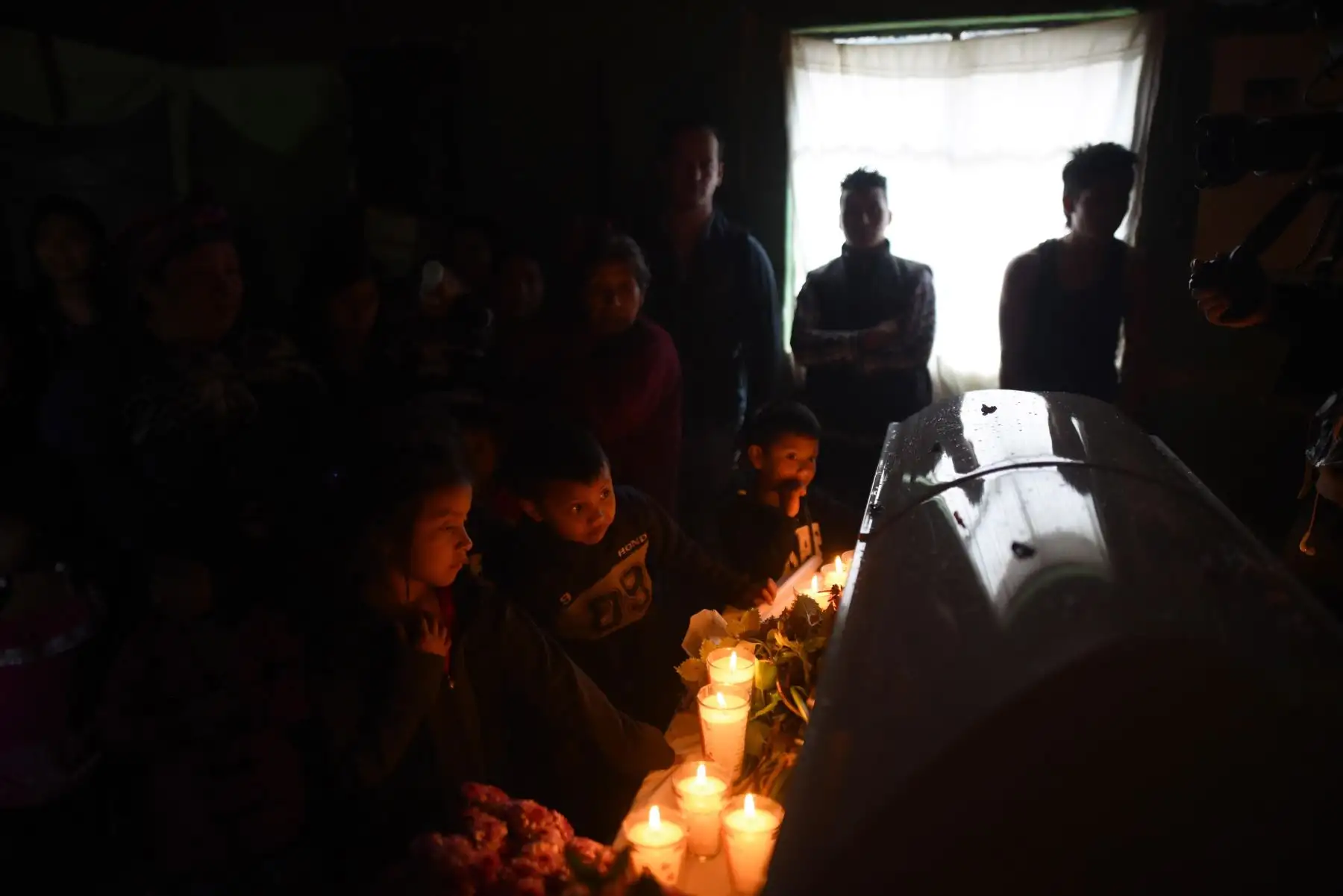 YALAMBOJOCH (GUATEMALA).- Los vecinos de Yalambojoch asisten al velorio del pequeño migrante Felipe Gómez. Los vecinos y la familia de este pequeño migrante que murió en Nochebuena en Estados Unidos, pueden poner punto y seguido a la crónica de un largo adiós. Los restos del pequeño son velados en su vivienda, una casa de madera con el suelo de tierra y el techo de teja que no cuenta ni con los servicios básicos.Foto: EFE/Edwin Bercián