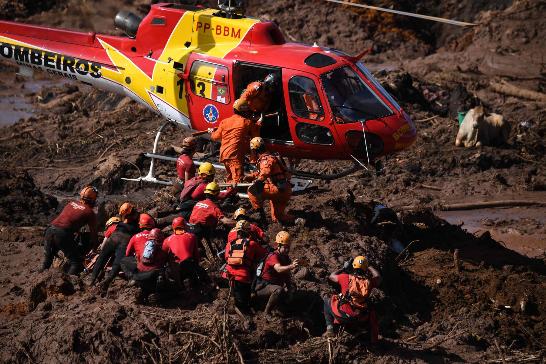 Un helicóptero brinda apoyo al trabajo de los rescatistas y bomberos en la búsqueda de víctimas Foto: AFP