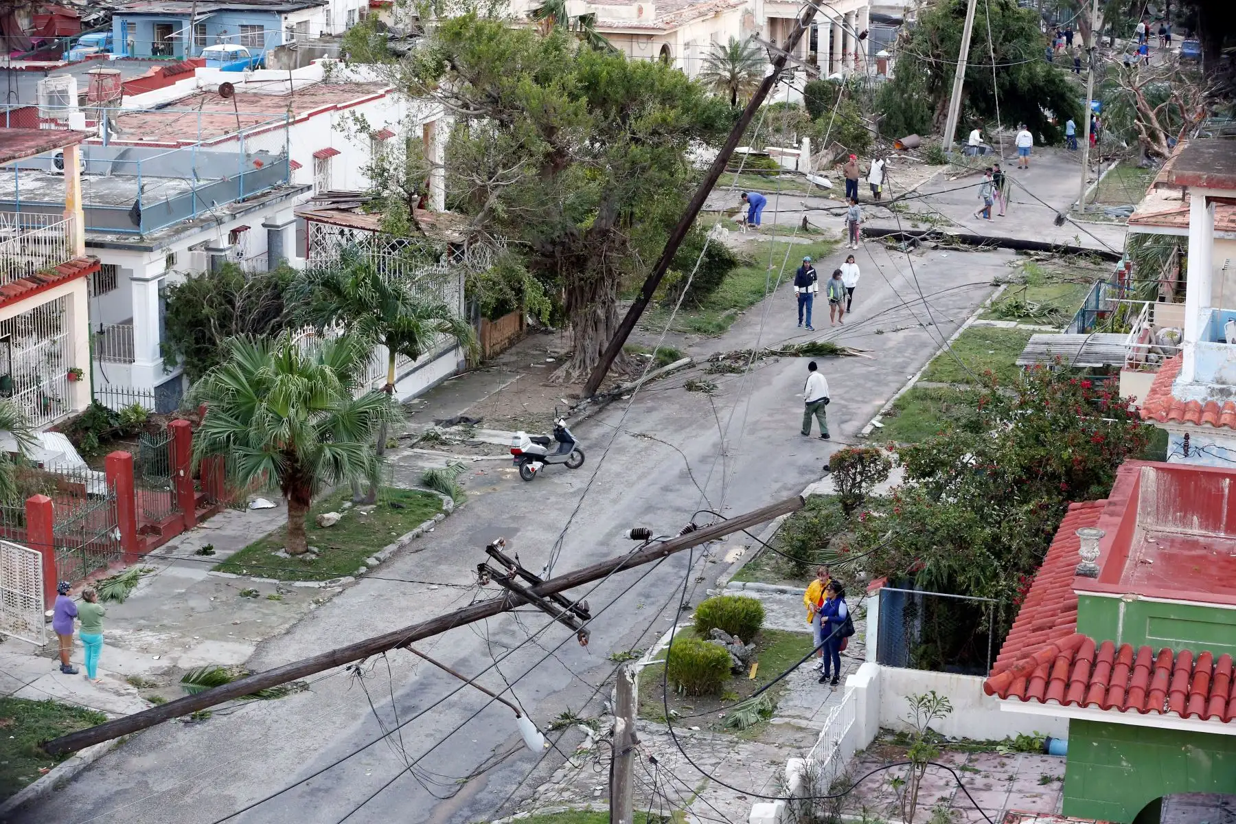 Vecinos caminan por una calle afectada por el paso de un tornado en La Habana (Cuba). Al menos tres personas han muerto y 172 han resultado heridas por un tornado que azotó esta madrugada la barriada de Regla, en La Habana. EFE/Ernesto Mastrascusa
