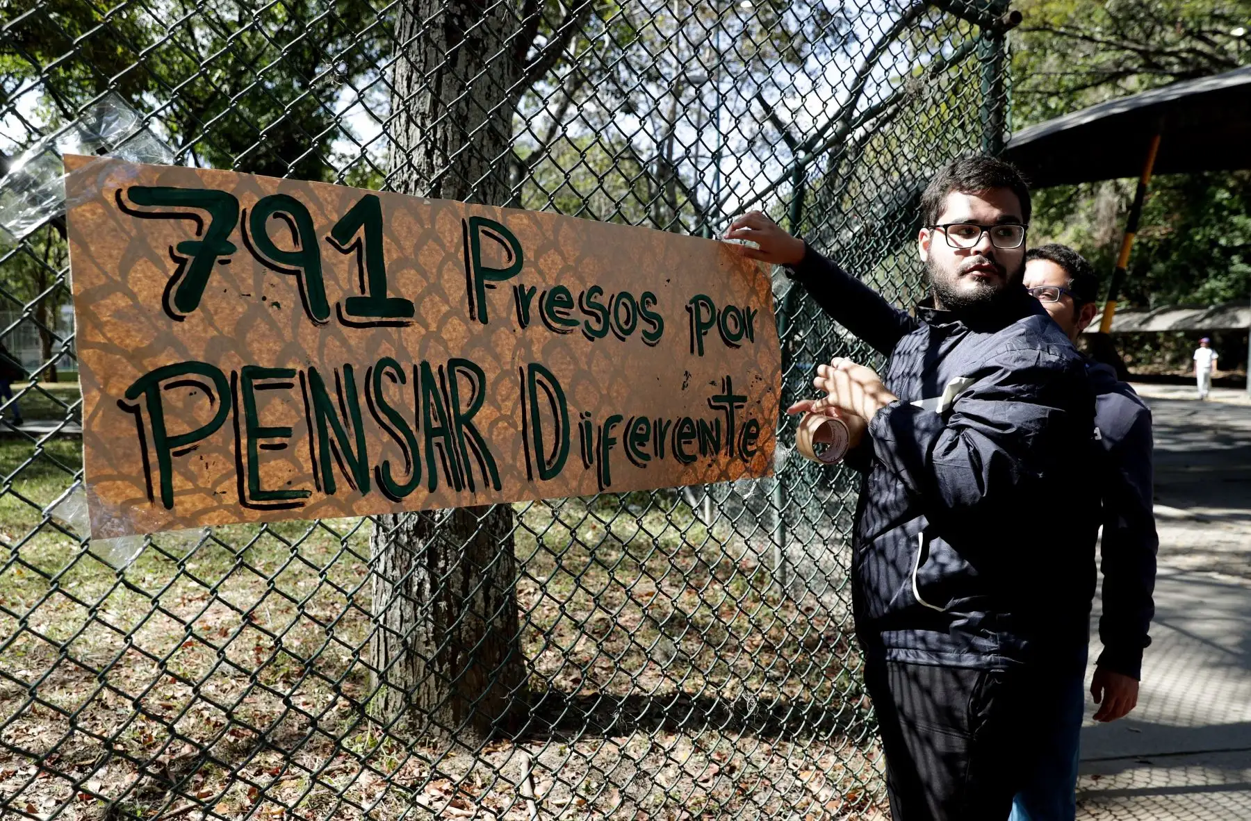 Estudiantes de la Universidad Central de Venezuela colocan un cartel luego de una rueda de prensa en la que presentaron su respaldo al jefe del Parlamento y autoproclamado presidente de Venezuela, Juan Guaidó, en Caracas (Venezuela). EFE/Leonardo Muñoz