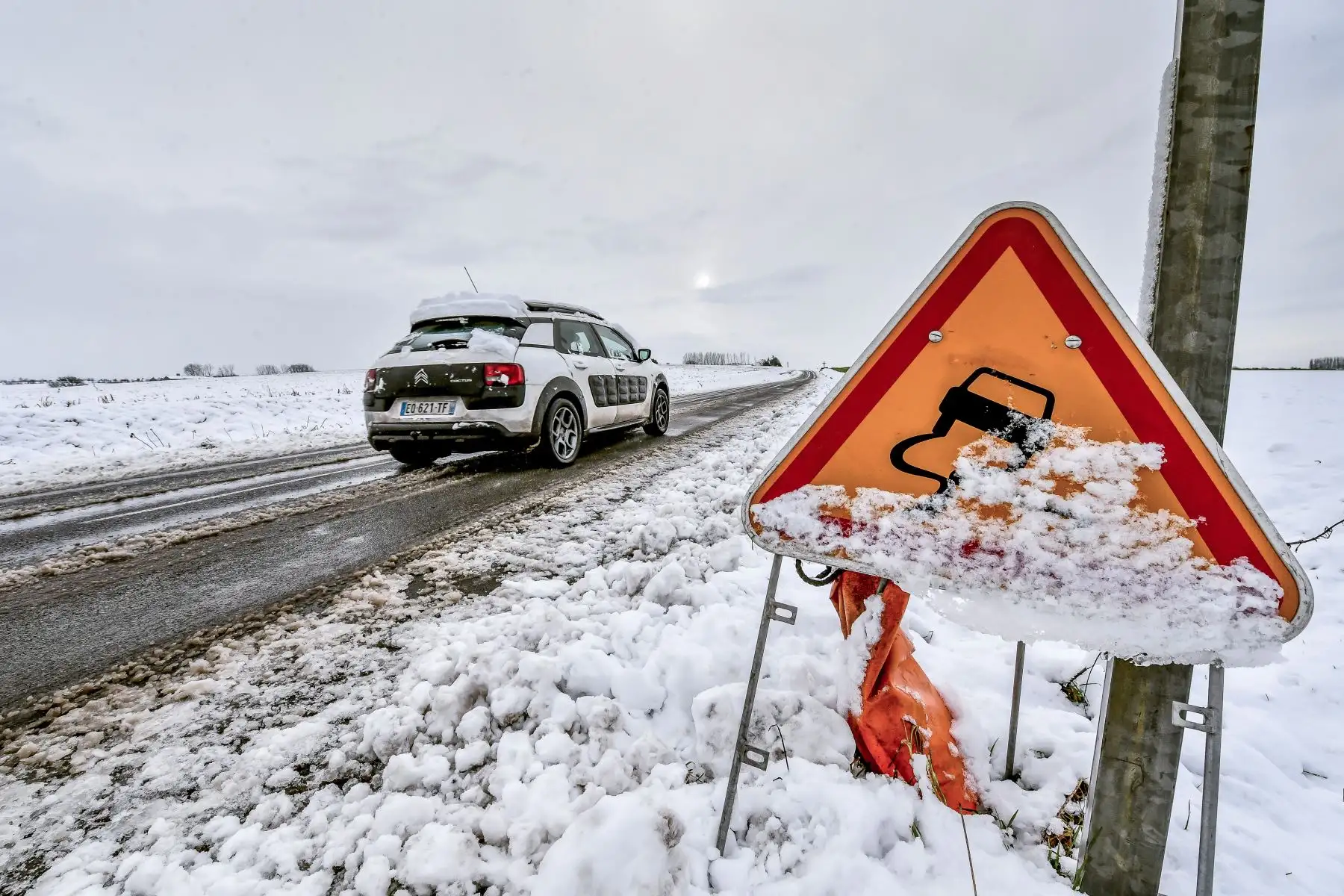 Un automóvil conduce por una carretera cubierta de nieve en Godewaersvelde, cerca de Lil e, 
 (Foto por Philippe HUGUEN / AFP)