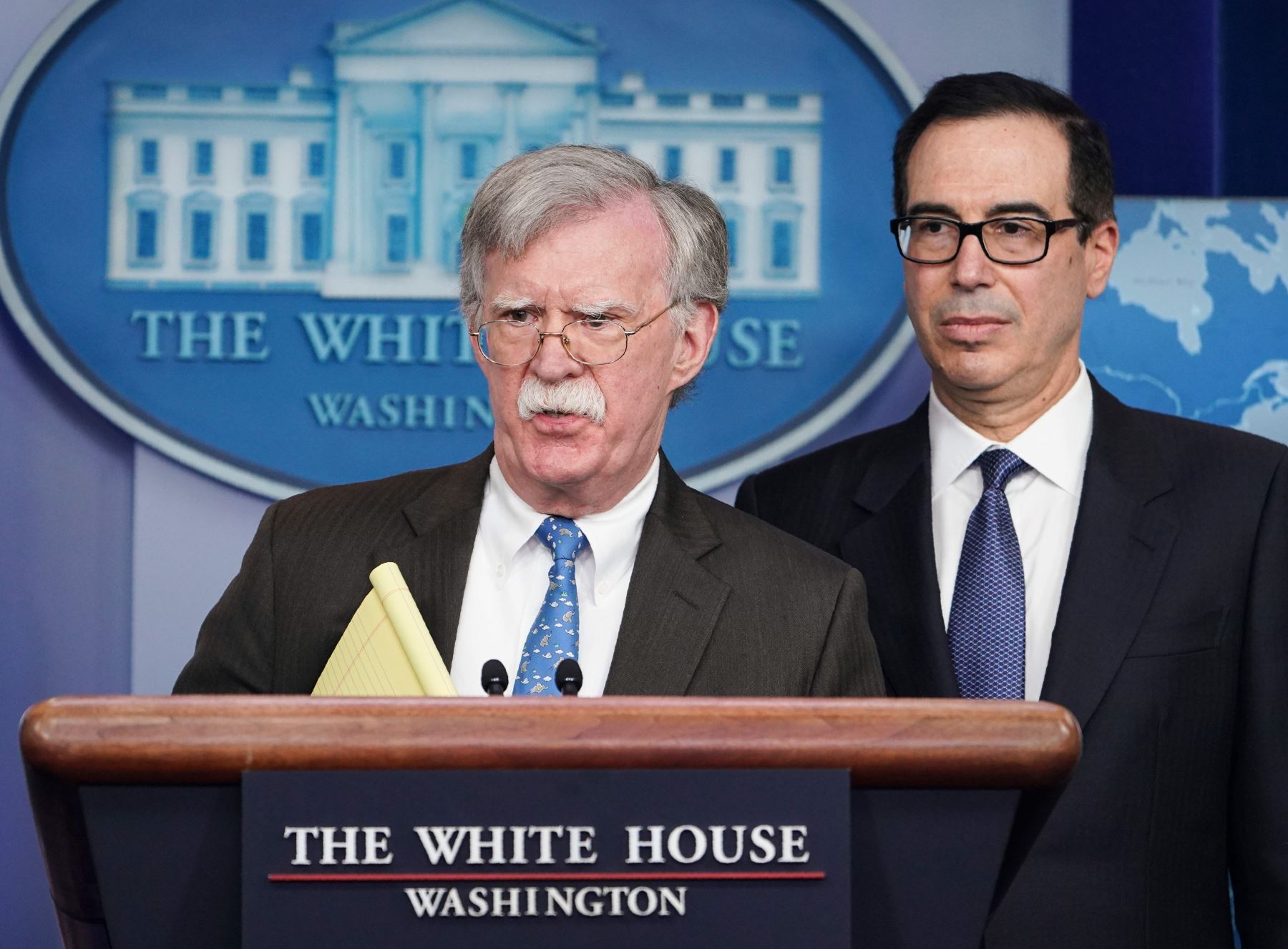 El asesor de seguridad nacional, John Bolton, habla mientras el secretario del Tesoro de los Estados Unidos, Steven Mnuchin, observa Foto: AFP